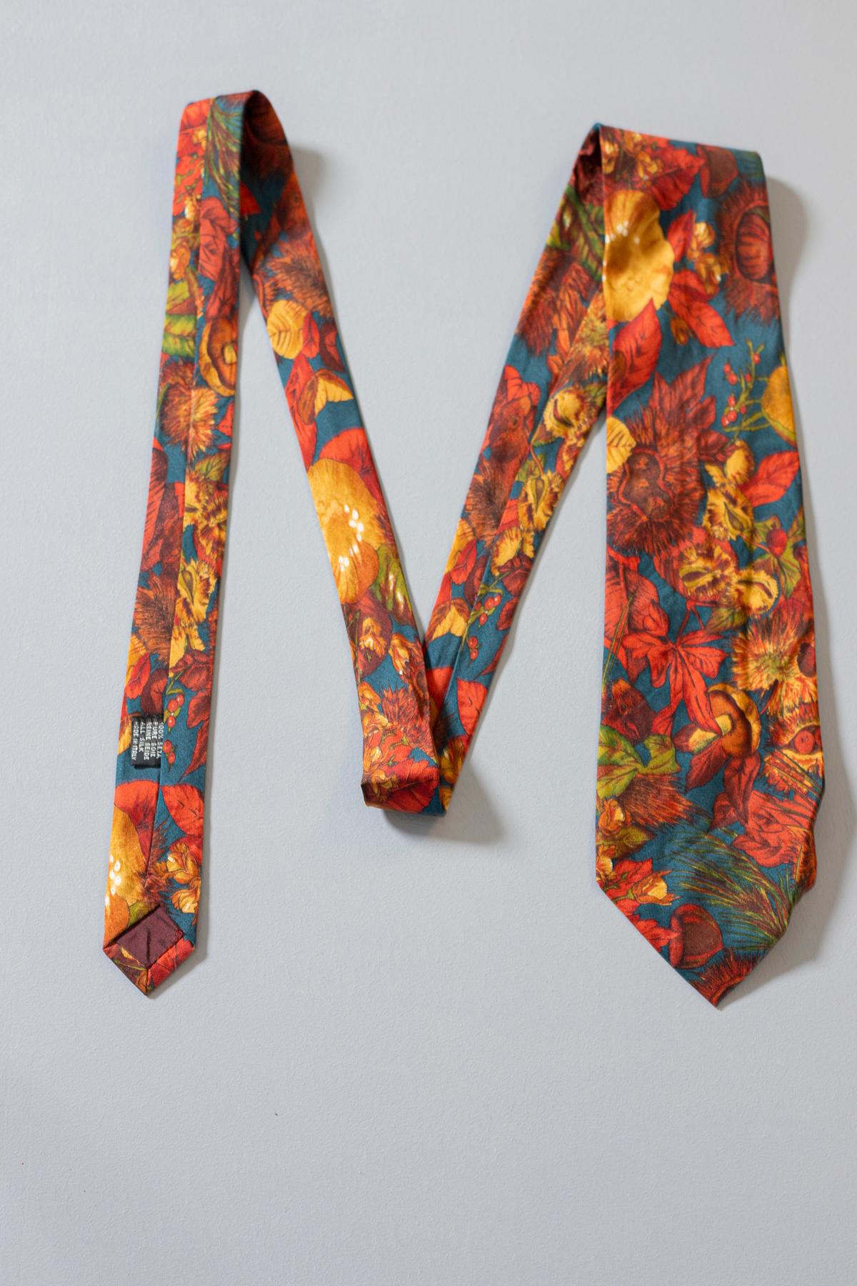 Colorful and particular tie designed by Reporter, it is made of silk. Decorated with designs of chestnut leaves and  squirrels, in bright and warm colors in shades of red.
It is the perfect tie for lovers of particular designs who want a look that