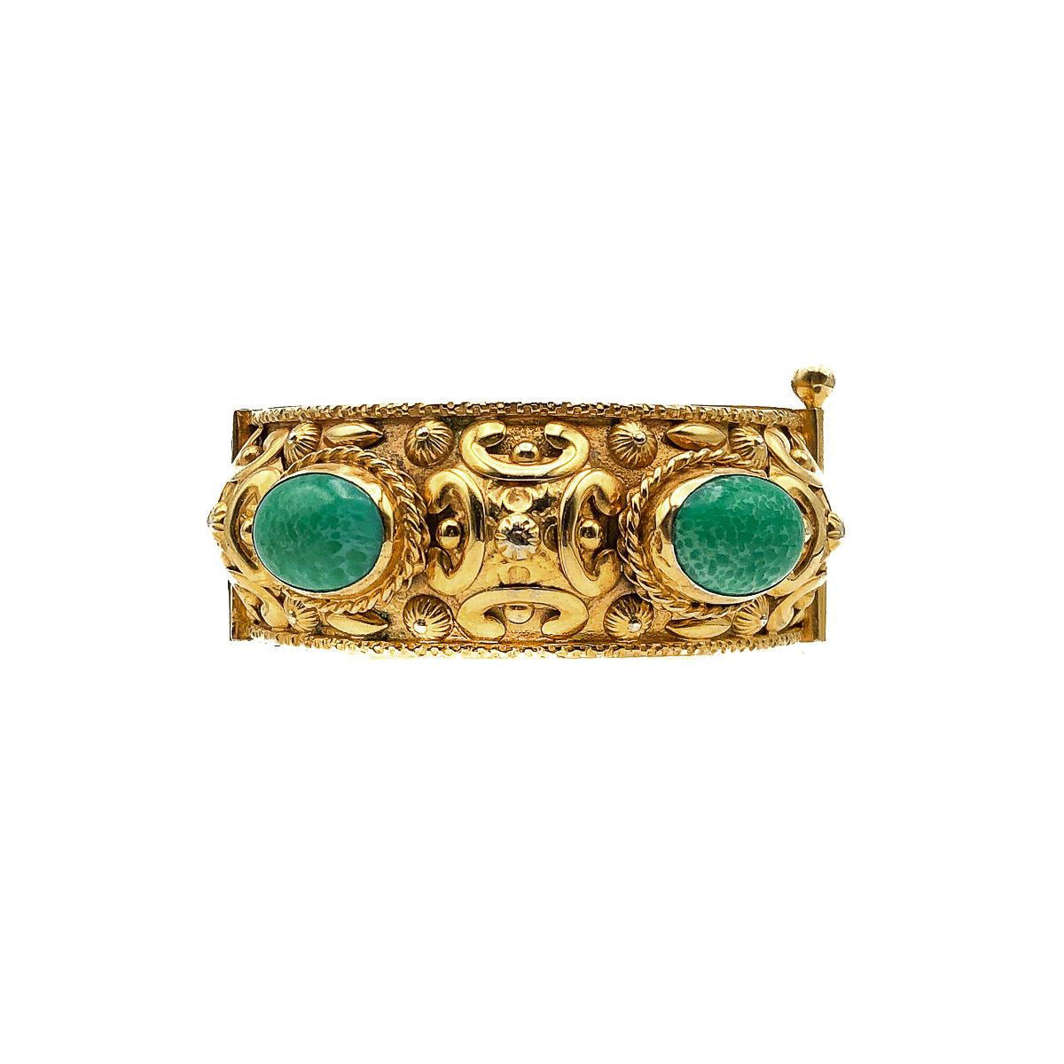 An exquisite Vintage Repousse Cabochon Bangle dating to the 1970s. Featuring four important jade green ceramic stones set within a wonderfully ornate and lustrous, gold plated repousse band. The repousse band is fringed with gold-plated braid and