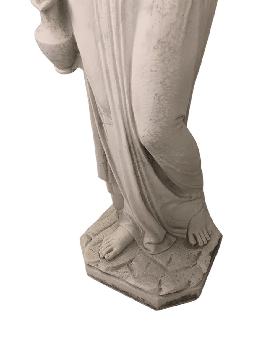 Reproduction vintage à moyenne échelle d'une statue antique de style gréco-romain. Elle représente Hébé, la déesse de la jeunesse dans la mythologie grecque et l'échanson des dieux. Hébé était la déesse de la jeunesse, fille de Zeus et d'Héra. Le