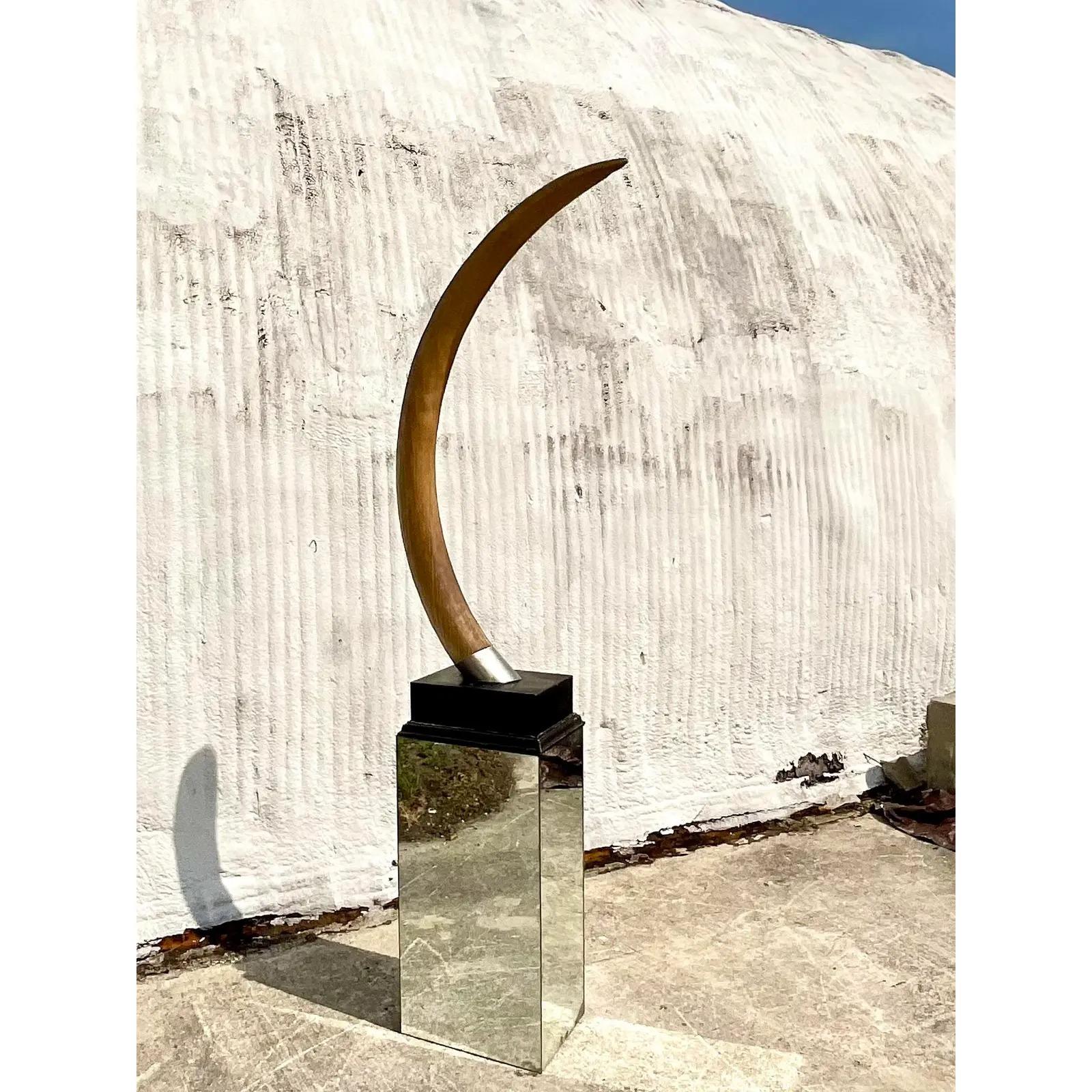Fantastic vintage faux resin elephant tusk. A monumental piece that rests on a black lacquered plinth. A wide chrome band at the base. Acquired from a Palm Beach estate.