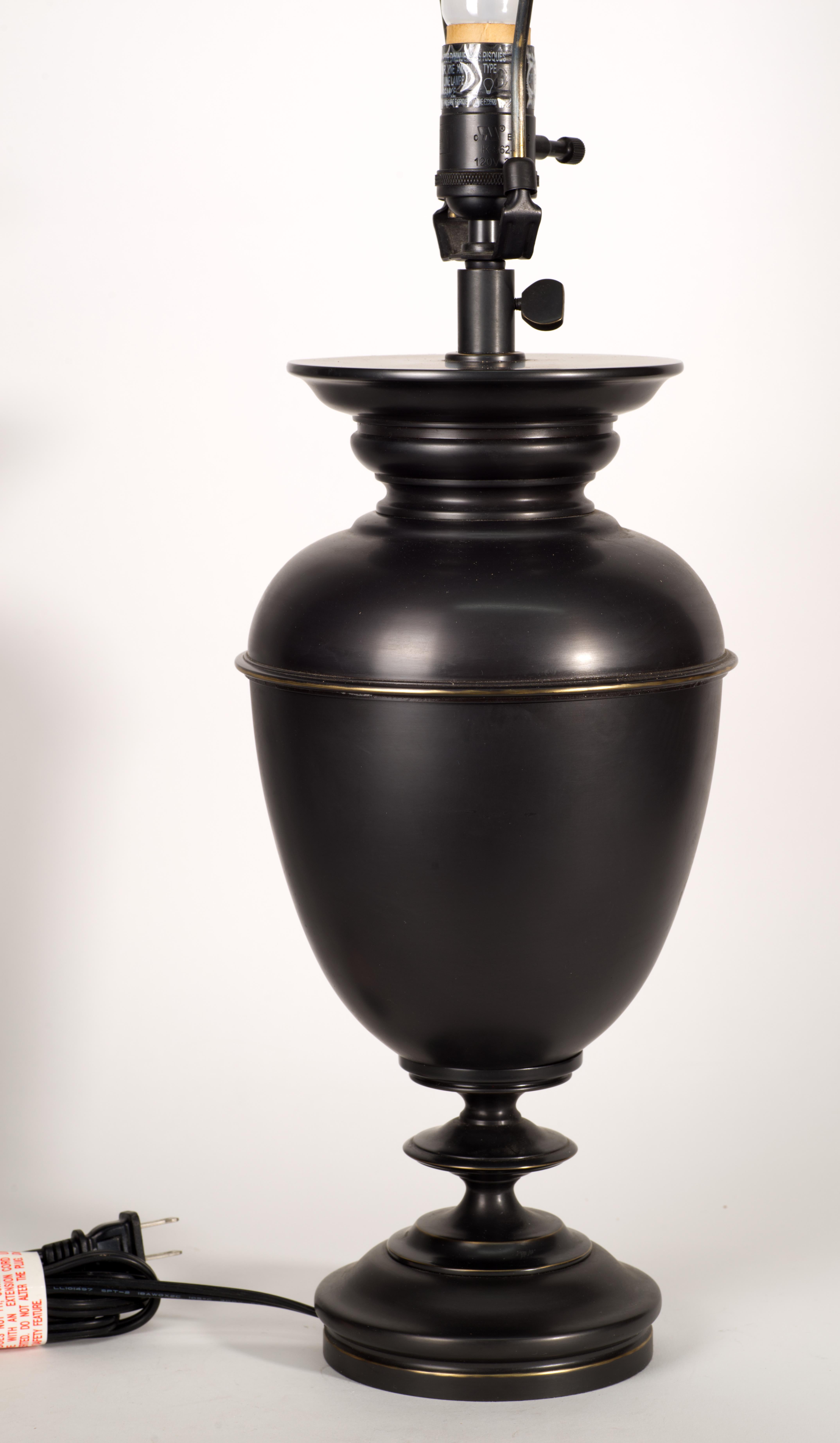 Vintage heavy, substantial table lamp features timeless urn shaped body in antique bronze or oil rubbed finish. The weathered patina like finish complements the traditional urn shape, and the figured finial balances the graceful lines of the lamp