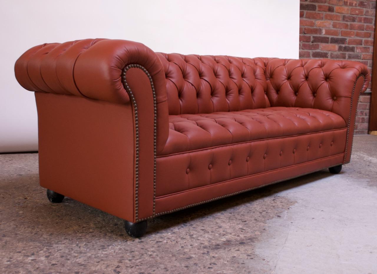 2-seat chesterfield sofa with button tufted detail, newly reupholstered in leather, circa 1970. Exceptional quality; no expense was spared in this full restoration including new foam, double hand-stitching, and applied brass nailhead trim details.