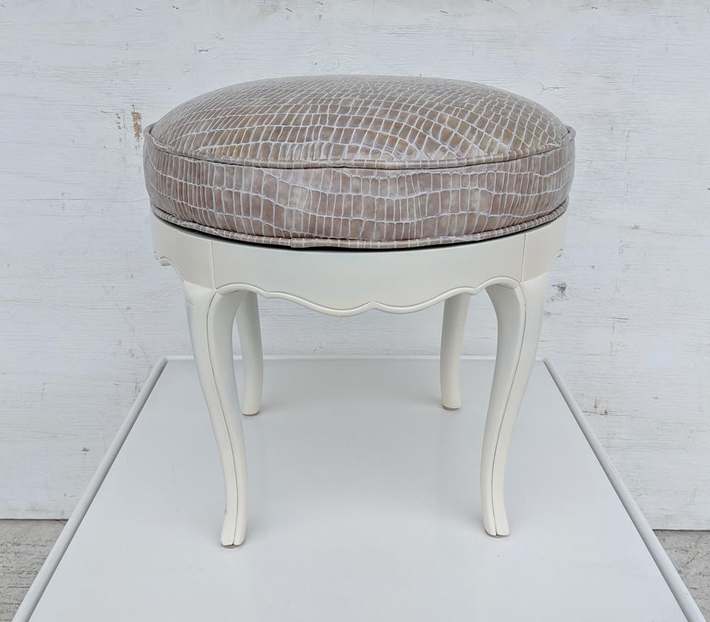 A glamorous antique swivel stool restored in a rich patent leather stamped in a reptile pattern. Base is painted in an antique white matte finish.

  