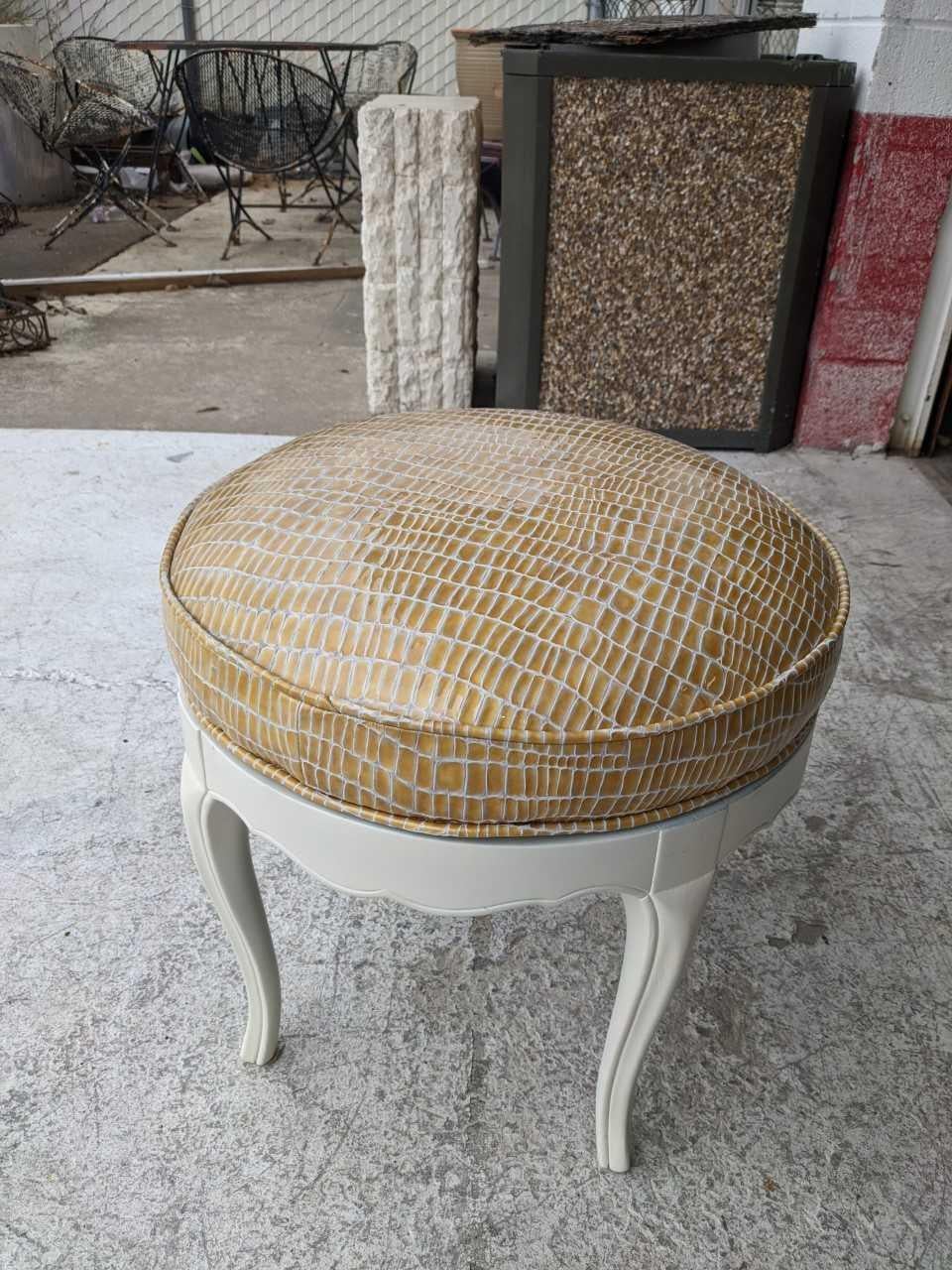 A glamorous antique swivel stool restored in a rich patent leather stamped in a reptile pattern. Base is painted in an antique white matte finish.


