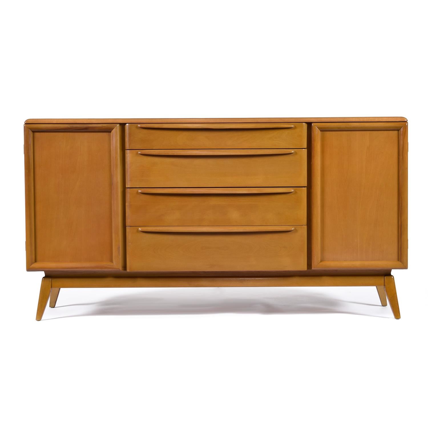 Versatility abounds with this Heywood Wakefield credenza.  Buffet, media cabinet, or entryway console are just a few ideas. As a dry bar, the adjustable / removable shelves will allow you to keep that whiskey collection cozy.  The top drawer sports