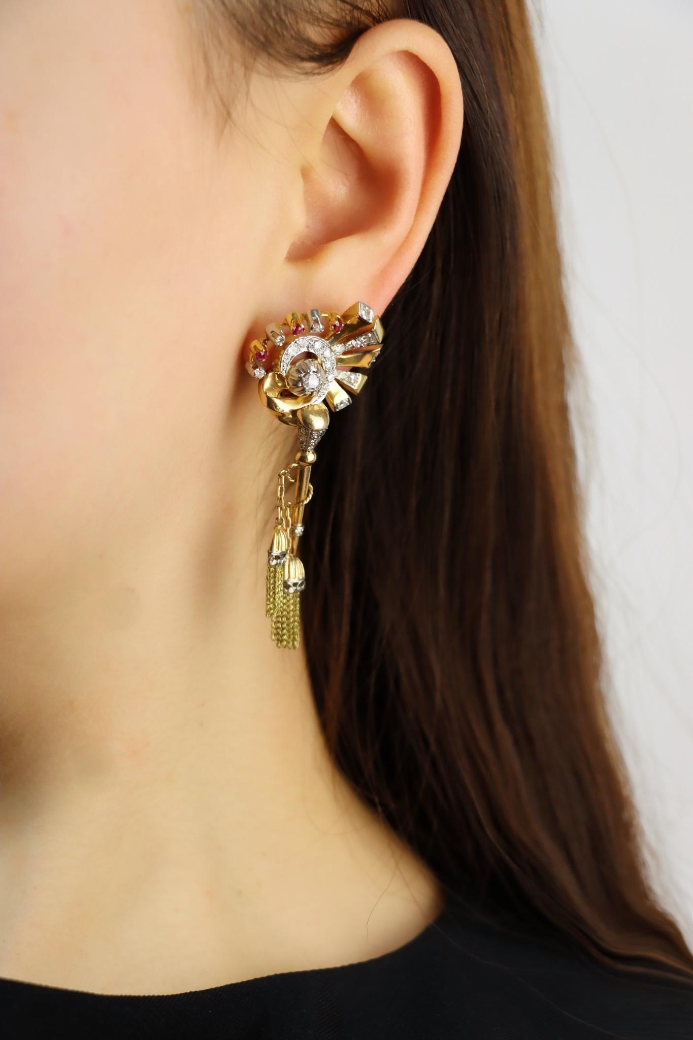 Vintage Retro 14K Gold Diamond Ruby Swirl Tassel Earrings

Approximate Dimensions:
5.3 cm (Length)
2.5 cm (Width)
Approx. 0.18 carat (Ruby)
Approx. 1.36 carats (Diamond)
21.0 grams in weight.

** All dimensions listed above are approximations based