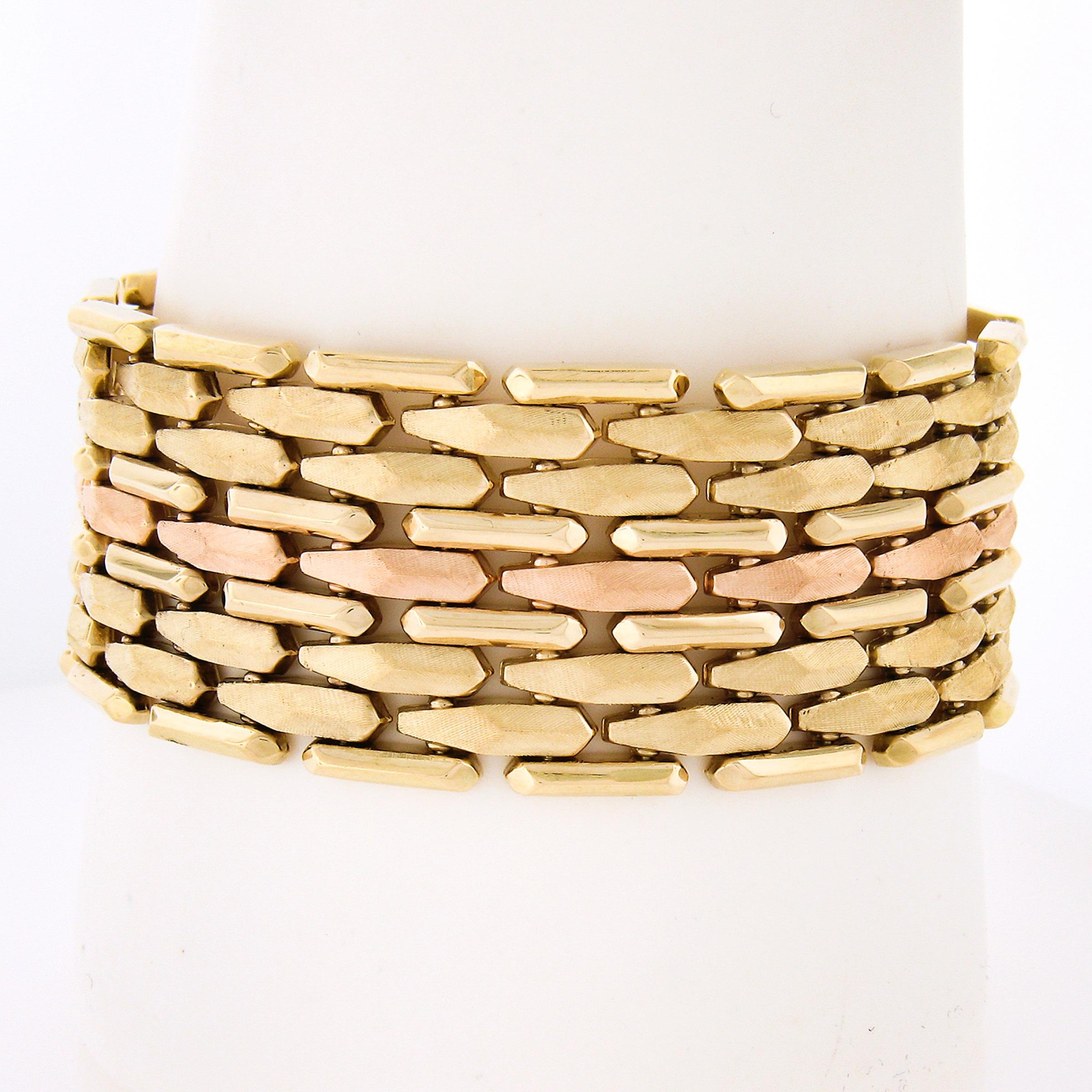 A gorgeous vintage bracelet that was crafted in solid 14k yellow & rose gold. This wide strap bracelet is constructed from multiple rows with textured and faceted polished links throughout. It is approximately 1 inch wide and has a flexible and