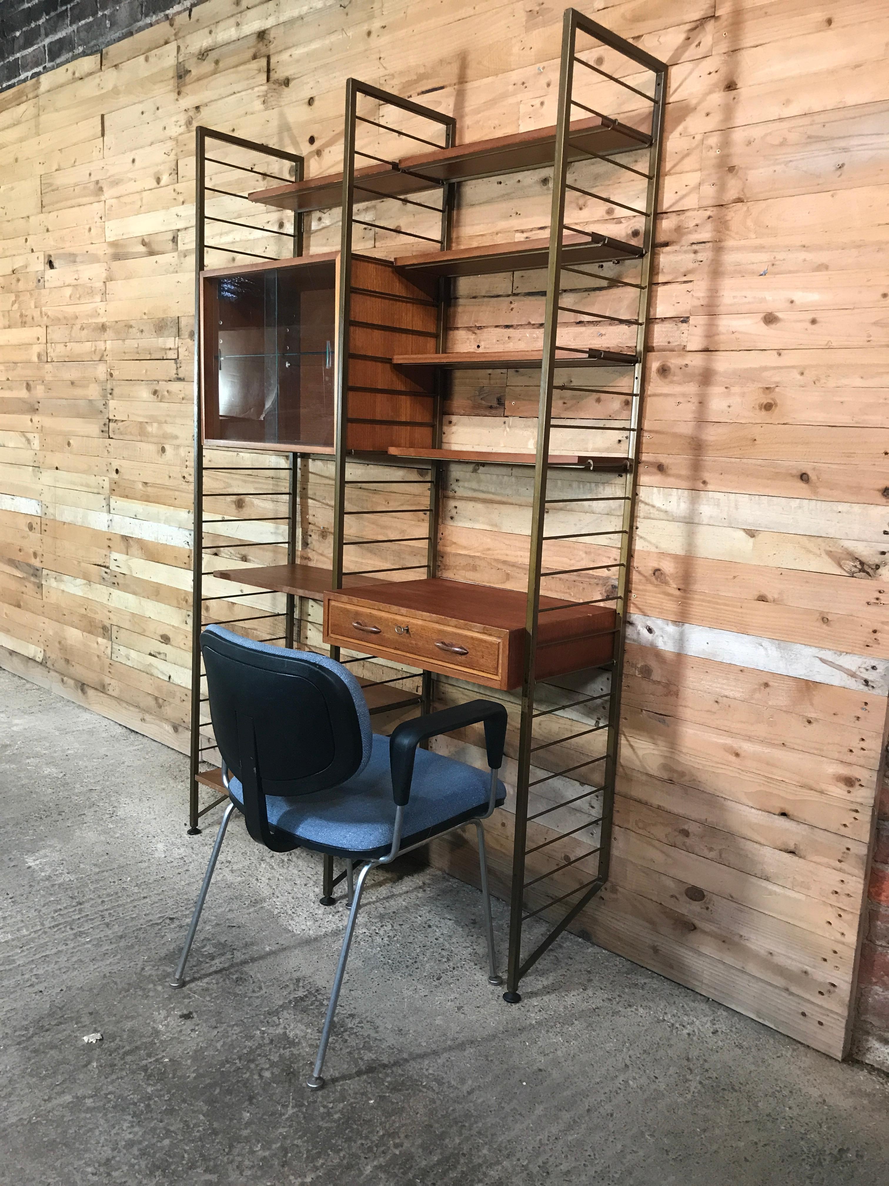 Stunning living room bronzed ladder wall system from the 1960s, it comes with 3 ladders and it has a cupboard with glass sliding doors and a drawer unit / desk, it has 8 shelves. A lovely design this set would hold everything you need, every plank /