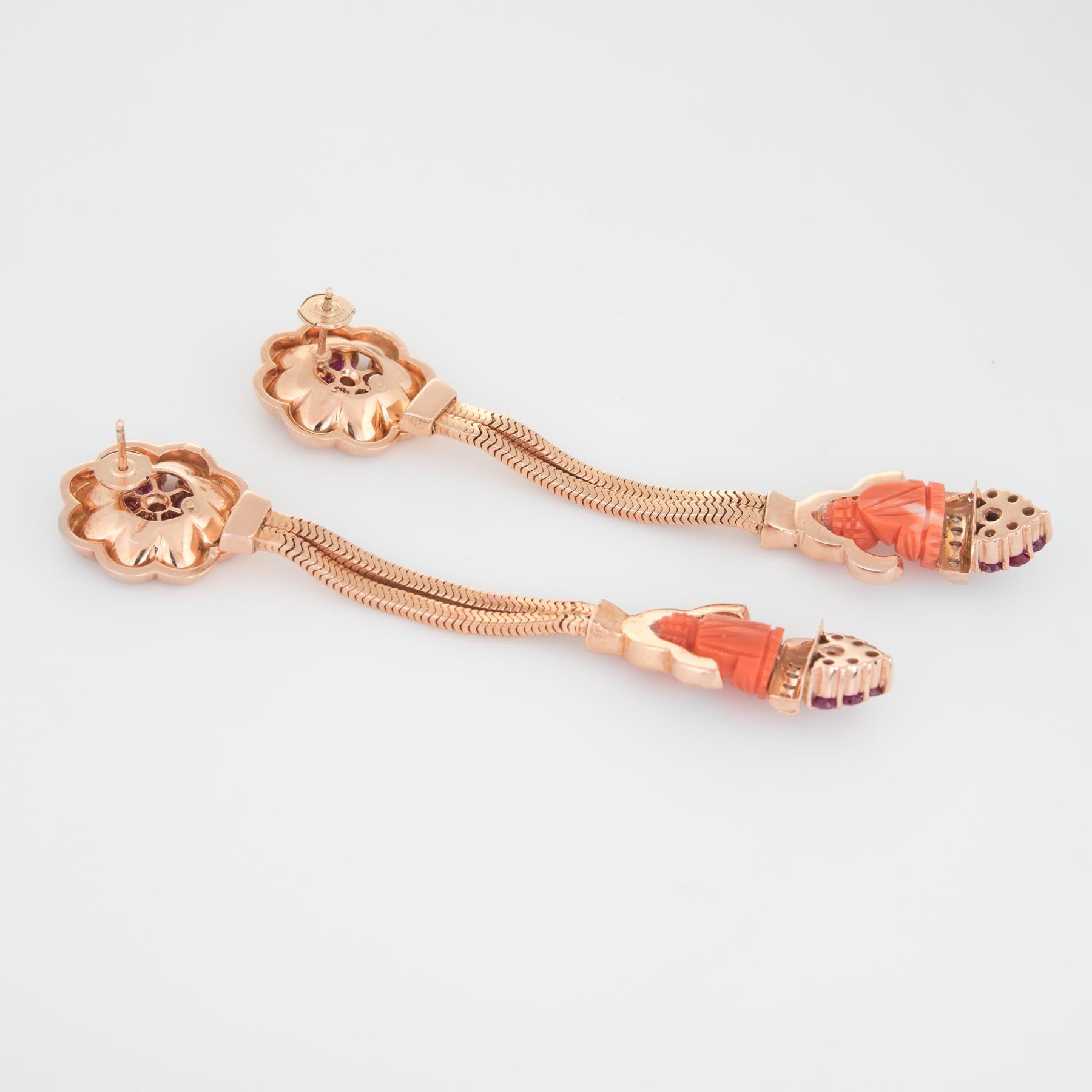 Fabulous pair of retro 1940s era coral Buddha earrings, crafted in 14k yellow gold. 

The coral is carved in the form of a sitting Buddha measuring 13mm x 10mm. The rubies total an estimated 2 carats. The diamond total weight is estimated at 0.30