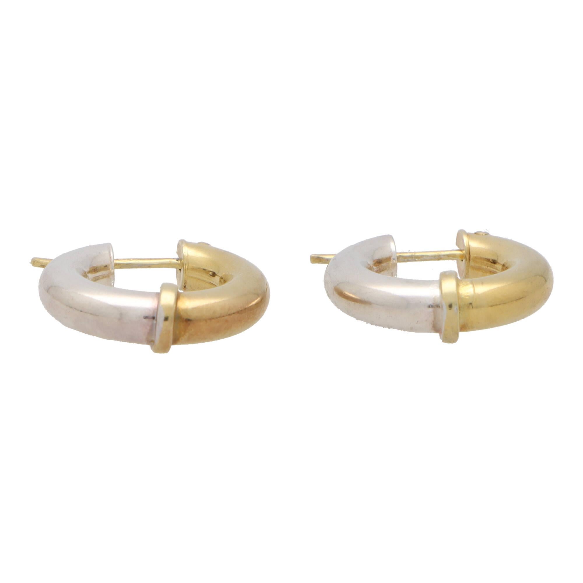 A stylish everyday pair of retro 9k yellow gold and silver chunky hoop earrings.

These fabulous earrings are composed of a 22-millimetre round hoop, split perfectly into two panels. The one panel being 9k yellow gold, and the other silver. The