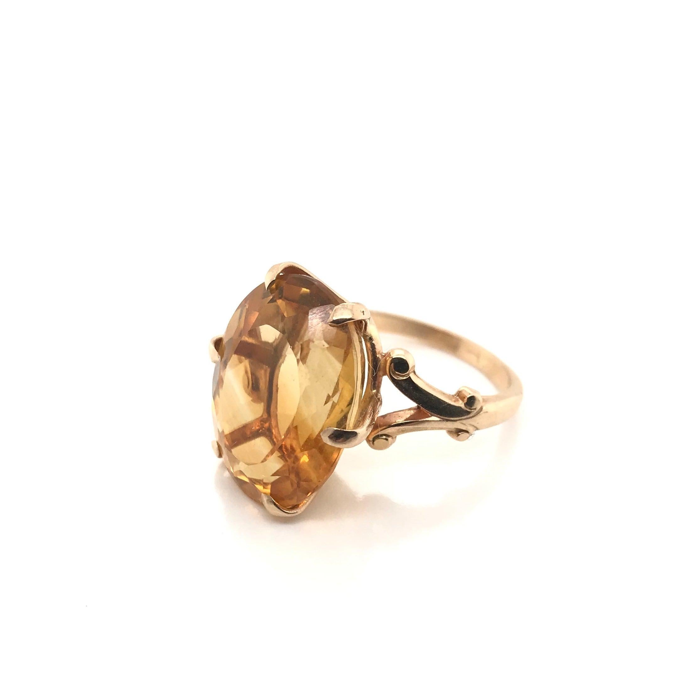 This stylish citrine cocktail ring was crafted sometime during the Mid Century design period (1940-1960). This retro piece features a large and fancy cut center Citrine secured by 6 claw prongs. The setting is 14K gold and features a stylized