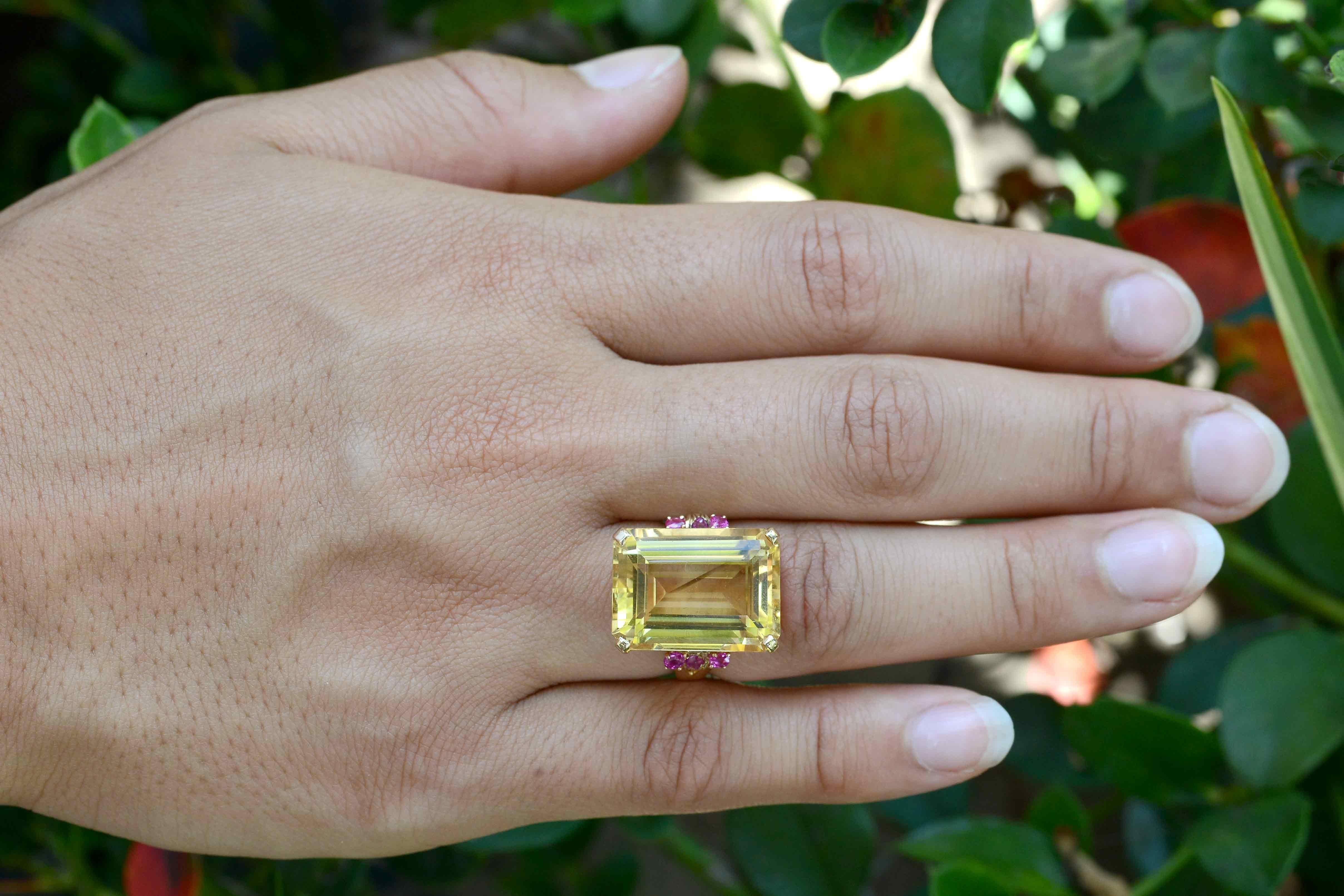 This 16.50 carat 1940's era retro citrine and ruby cocktail ring is a beautiful example of mid century jewelry. The huge, emerald cut gemstone sits in a 14K yellow gold cradle with 3 wonderful bright rubies on each shoulder that really compliment