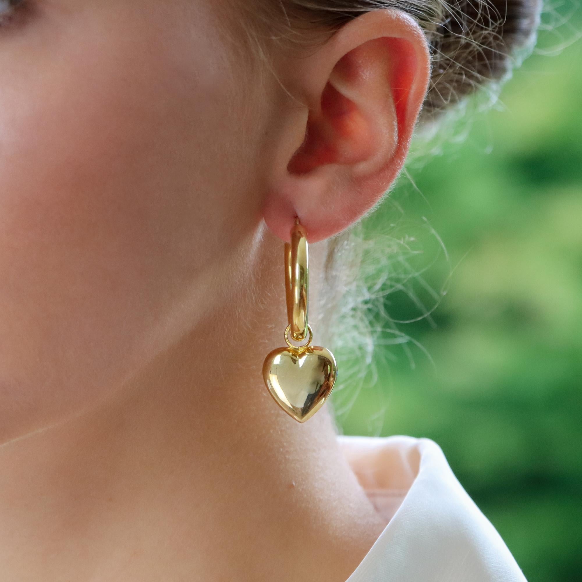 A stylish everyday pair of retro convertible heart hoop earrings set in 9k yellow gold.

These fabulous earrings are firstly composed of a large 28-millimetre round hoop. Suspending from the hoop is a detachable heart drop which freely hangs and