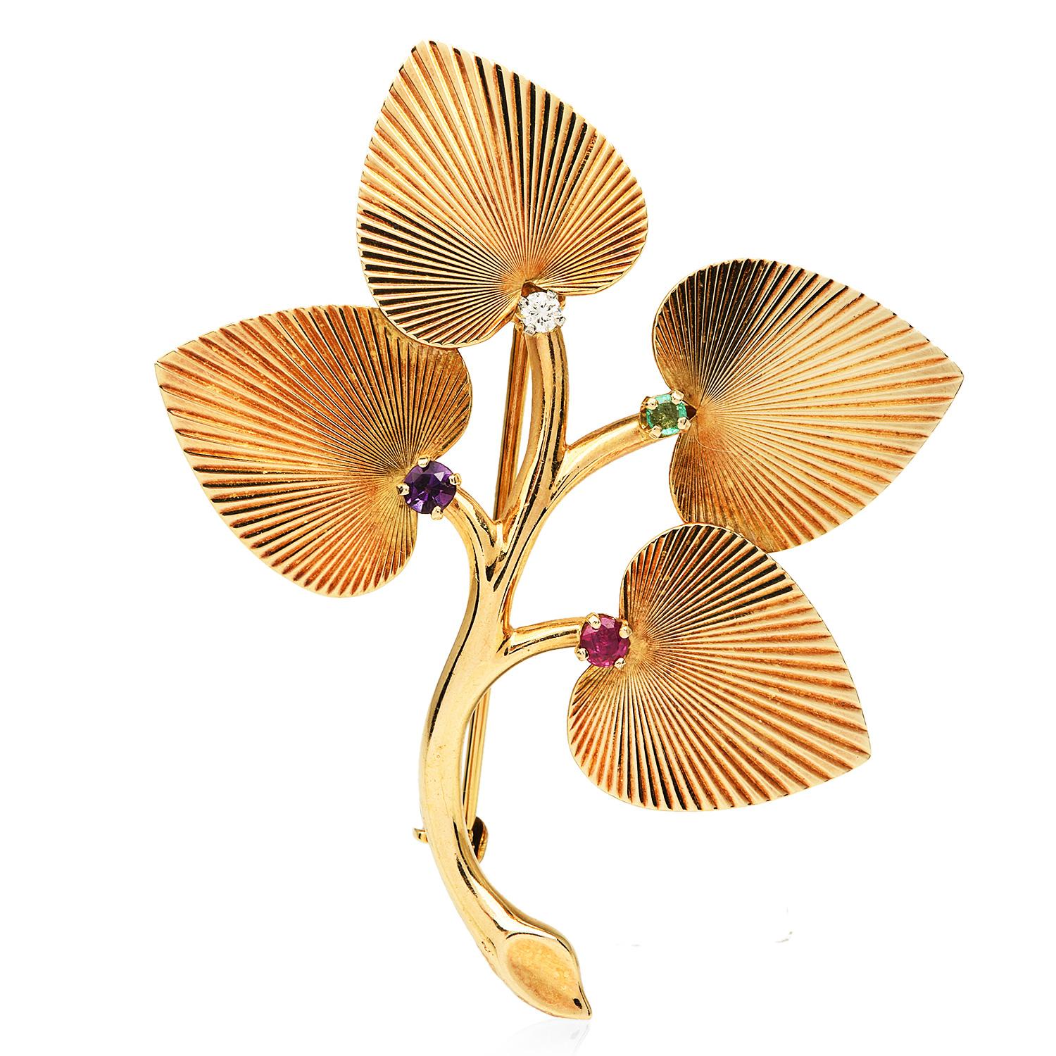 Vintage retro 1970s brooch pin, with a Floral textured leaf design.

Crafted in 14K Yellow Gold, they are composed of one round-cut Diamond, G-H, clarity VS.  weighing approximately 0.04 carats. Adding a touch of color, one Amethysts, Emerald & Ruby