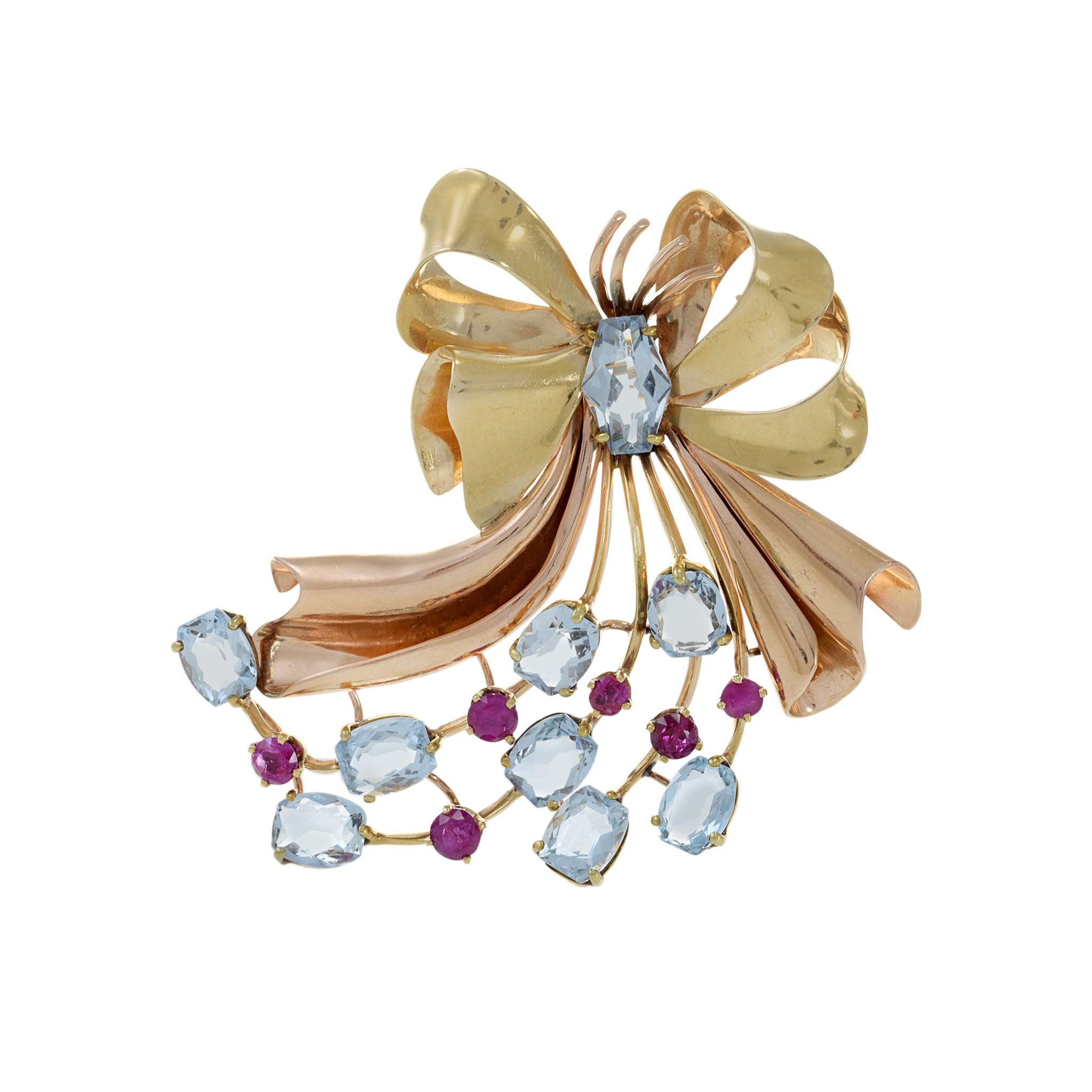 Crafted from high-quality 14KT yellow/rose gold, this ribbon pin exudes timeless elegance and sophistication. Embedded with genuine 13.30CT-TW aquamarines and 1.90CT-TW ruby gemstones, it's the perfect accessory to elevate any outfit. 25.59 grams