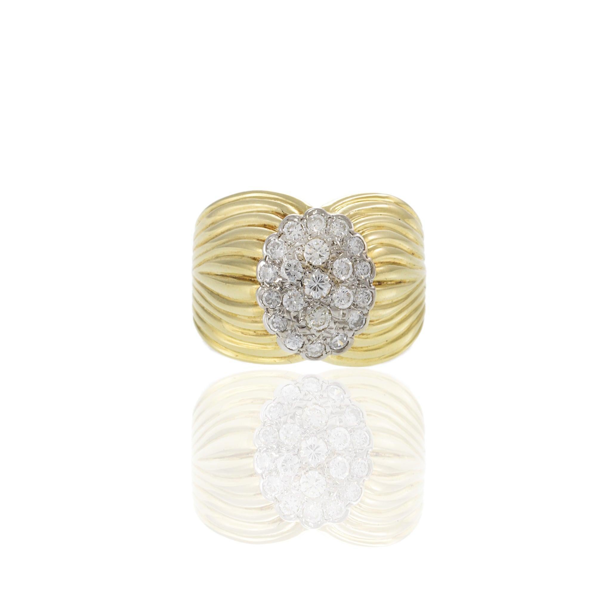 Questo splendido anello Retro Era è realizzato in oro giallo 14KT e sfoggia un audace design a coste, caratteristico della metà del XX secolo. Il centro è costituito da un bellissimo gruppo ovale di diamanti taglio rotondo, per un totale di 0,60
