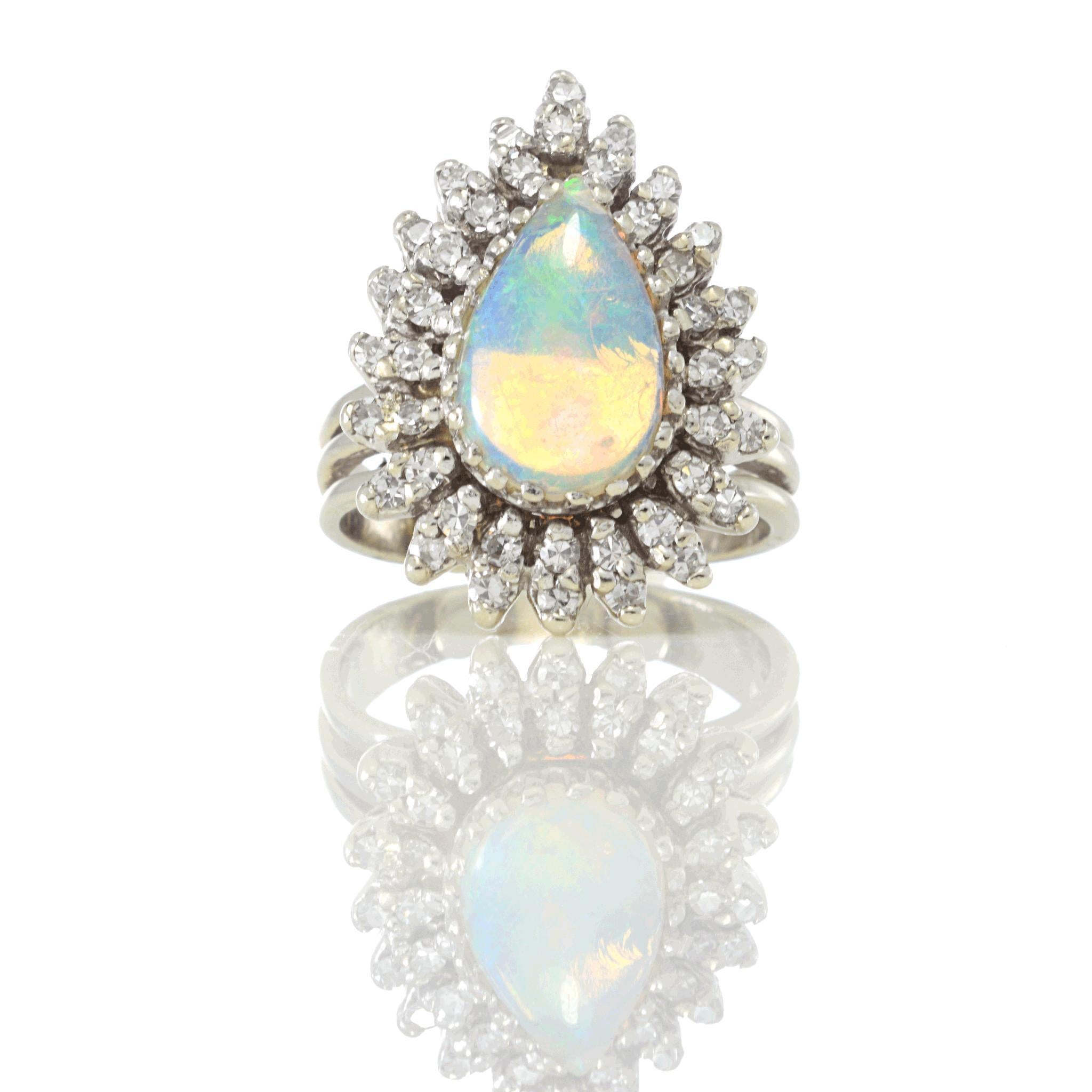 Sorprendente Anillo de Cóctel de Ópalo Australiano y Diamantes de la Época Retro, con un cautivador Ópalo talla pera engastado en Oro Blanco de 14k, rodeado de 1,2 quilates de Diamantes blancos talla única con claridad VS y grado de color H.

Tamaño