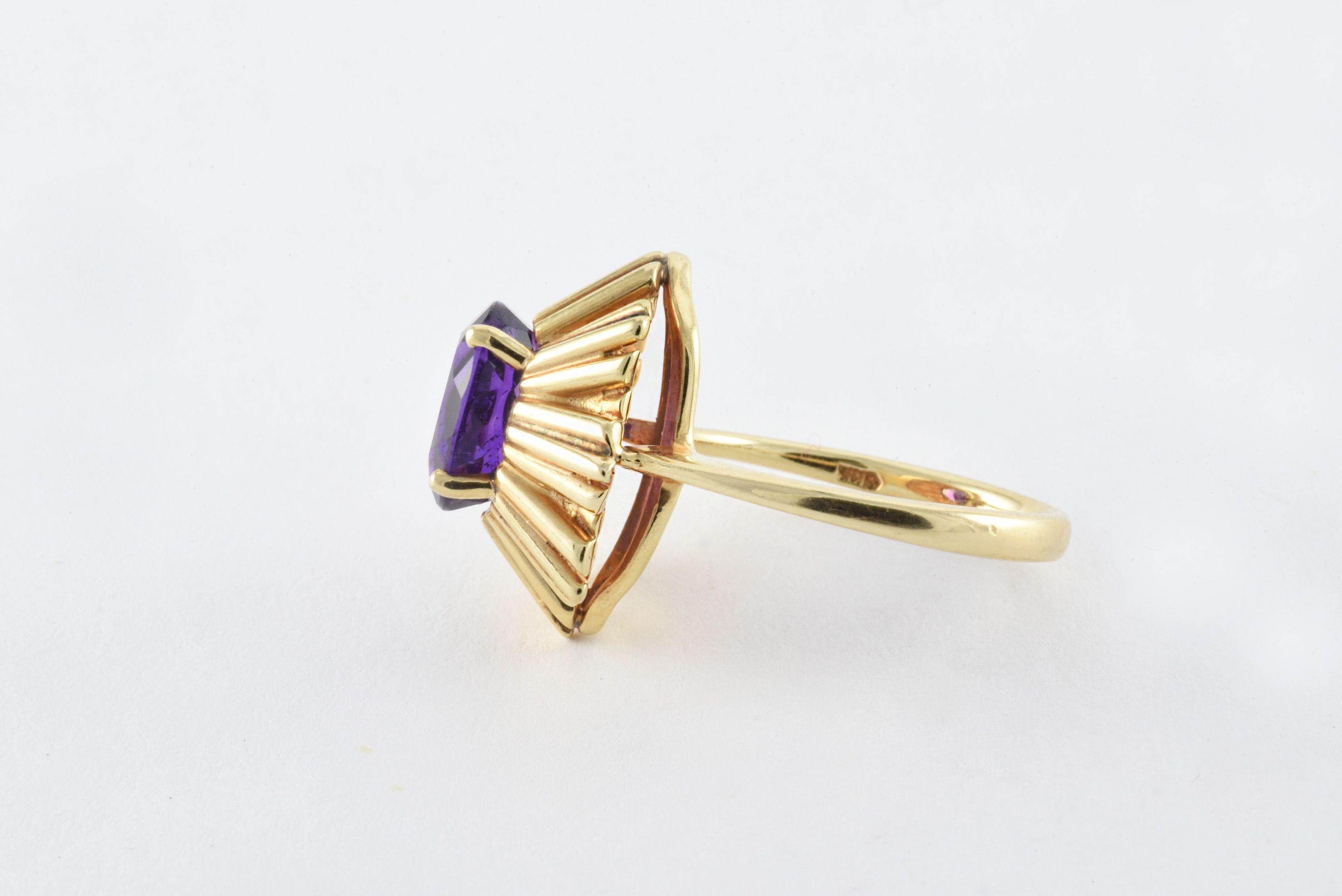 This distinctive vintage band crafted from 14kt yellow gold is designed around a purple oval-shaped Iolite measuring  9.26 mm x 7.39 mm and approximately 2.00 carats.
