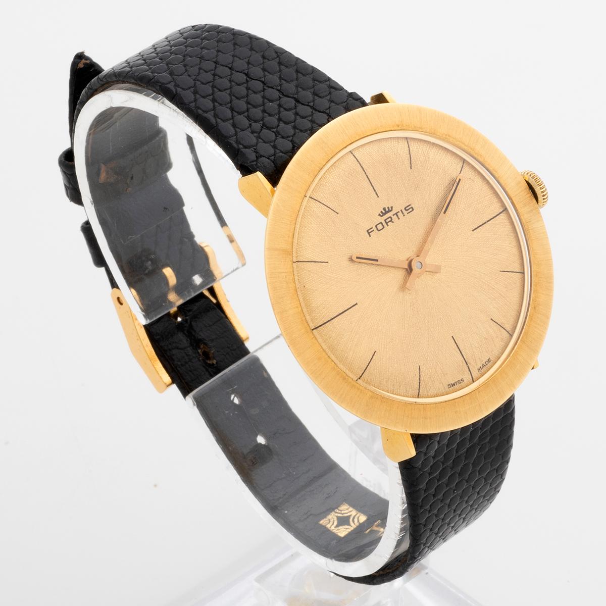 Our vintage and very retro Fortis features a manual winding movement and has a wonderful 18k yellow gold case which measures 33.5mm exc crown, 35mm inc crown. Fabulously styled, the sunburst effect brushed gold dial blends to the case. The original