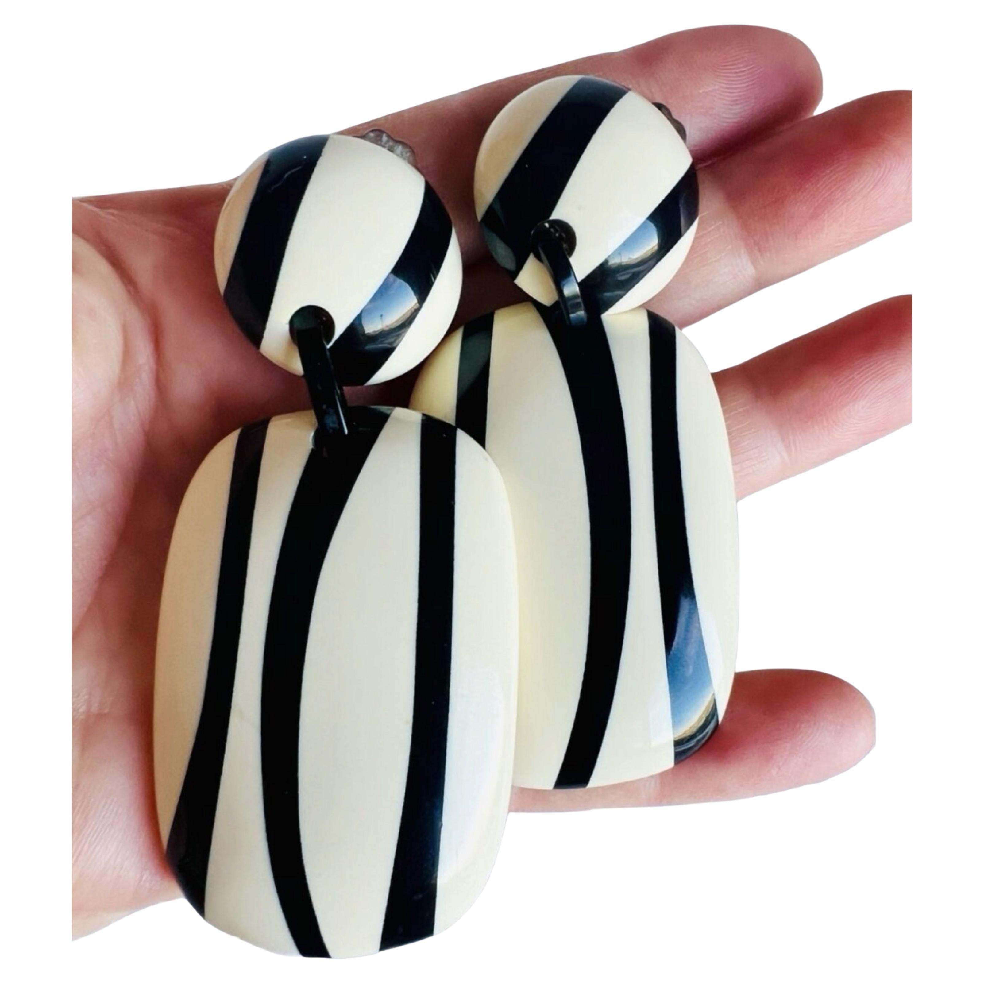 These extra large vintage earrings are a stunning addition to any jewelry collection. The black and white resin material gives them a retro feel, while the geometric shape and long dangle design provide a modern twist. The clip-on closure makes them