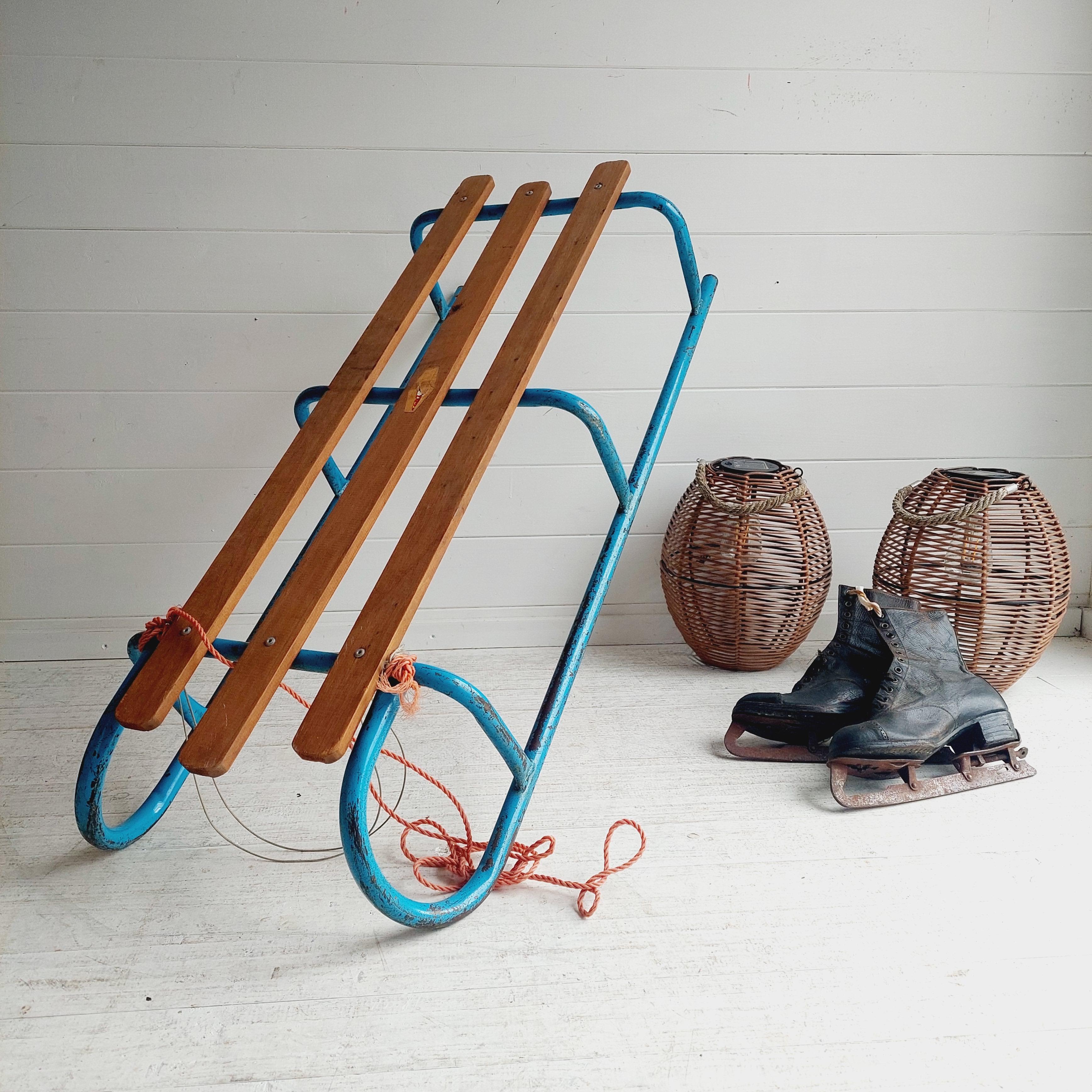 The classics are definitely the best and this wooden slatted sledge is no exception. 

This sledge would make for a great prop or decorative piece this winter and all year along.
Vibrant Blue steel metal frame with wooden slats.
Manufactured by Play
