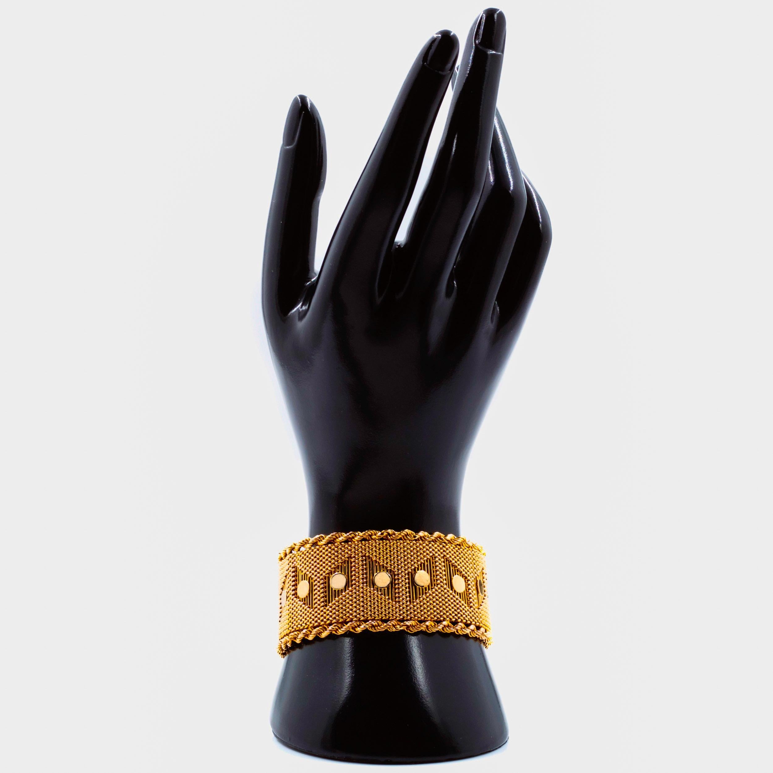 18K YELLOW GOLD MID-CENTURY MODERN WOVEN BRACELET
Item # 101PJR07R 

This gorgeous bracelet features a distinct geometrical design with parallelogram formations holding a high-polish circle surrounded by incredibly dense and complex weaving, the