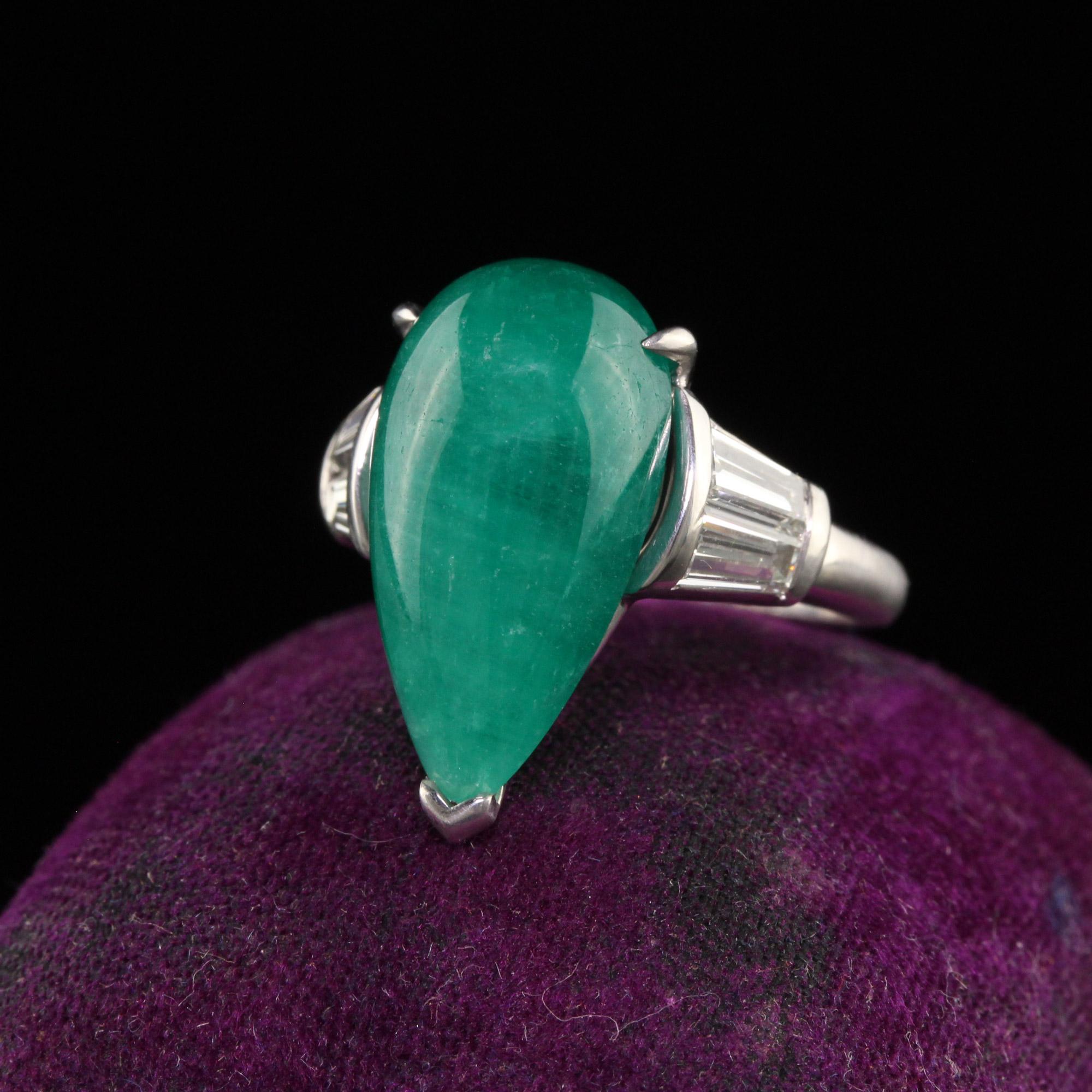 Beautiful Vintage Retro Platinum Colombian Emerald Pear Cabochon Diamond Ring. This beautiful ring is crafted in platinum. The center holds a natural Colombian emerald with large tapered baguettes on each side. The ring is in great condition and