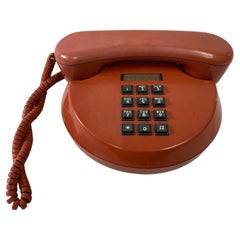 Vieux téléphone rétro à bouton poussoir rond orange brûlé des années 70