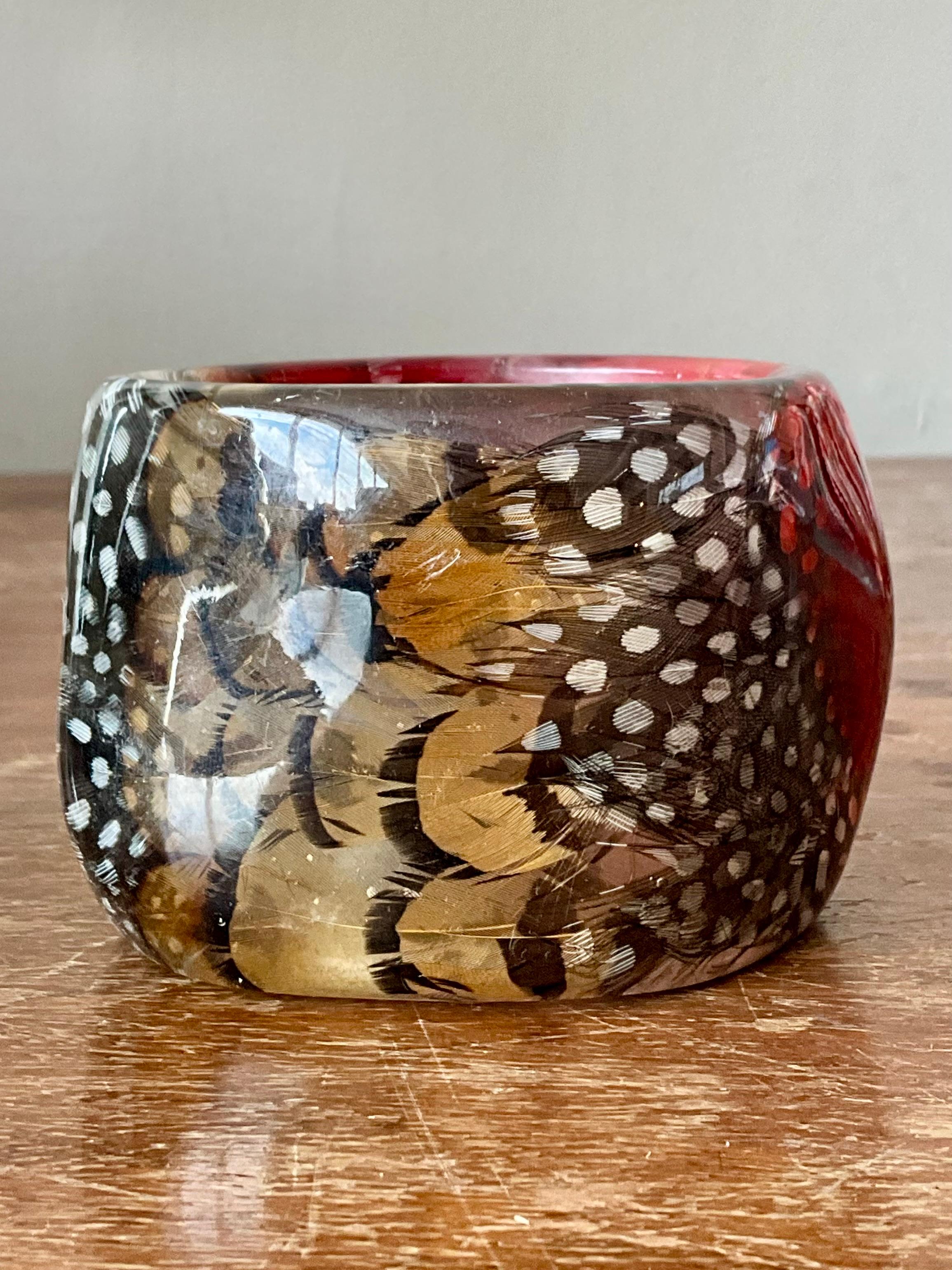 This vintage retro resin feather bangle is a bold and whimsical accessory that captures the playful spirit of mid-century fashion. Crafted from lightweight resin, the bracelet features a dynamic feather motif embedded or carved into the surface,