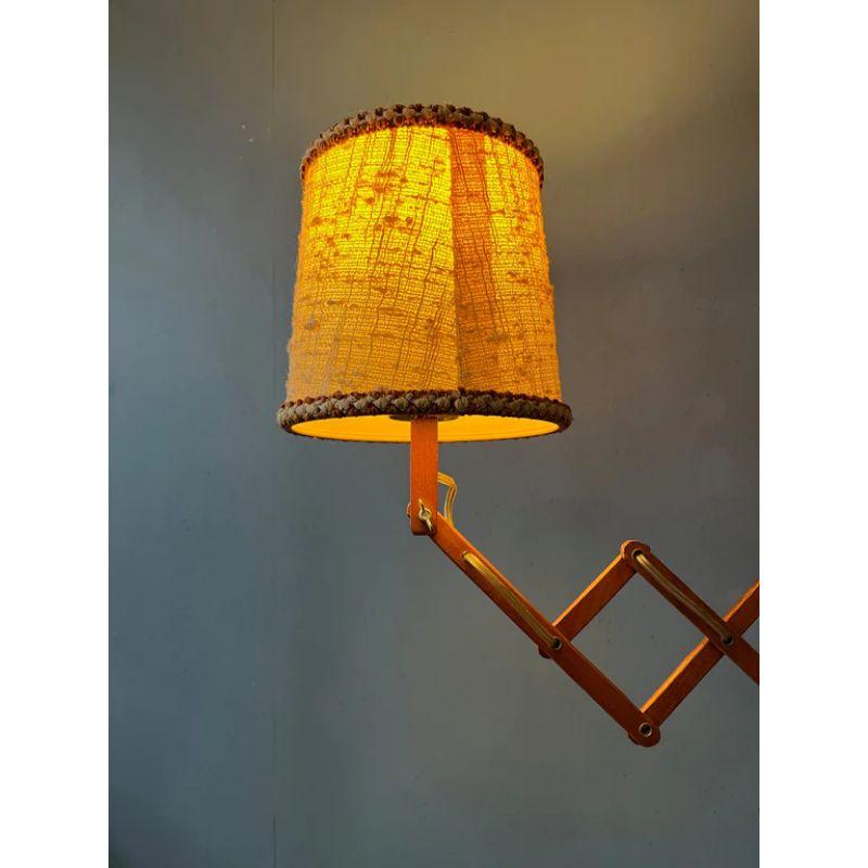 Dutch vintage scissor lamp with cosy, textile shade. The scissor-mechanism is made out of wood and the shade out of textile. The lamp requires an E27 (standard) lightbulb and currently has an EU-plug.

Dimensions: 
ø Shade: 23 cm
Height: 30