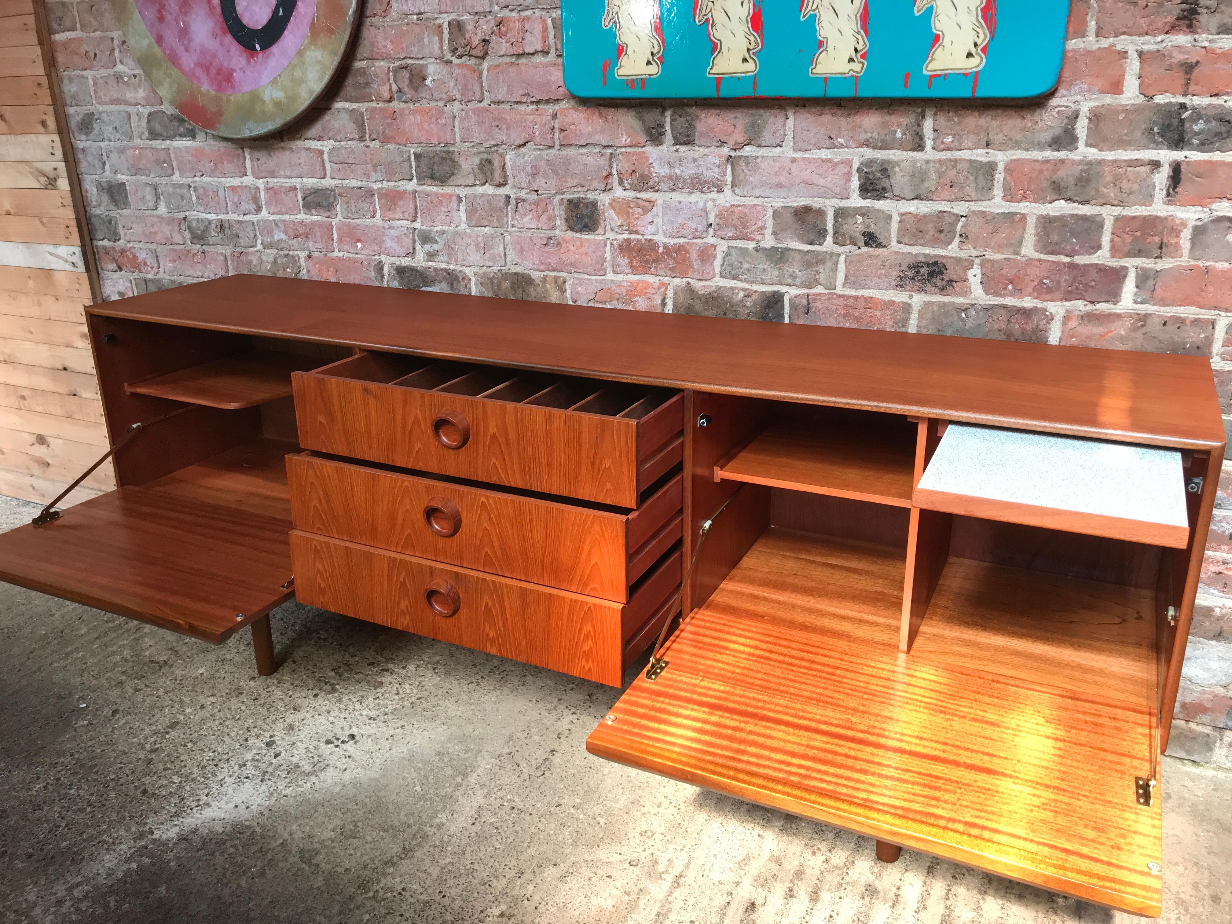 Vintage 1960s McIntosh sideboard by Tom Robertson. It has three drawers, cupboard space, and a drinks section with a useful pullout shelf. Credenza is in very good original condition.