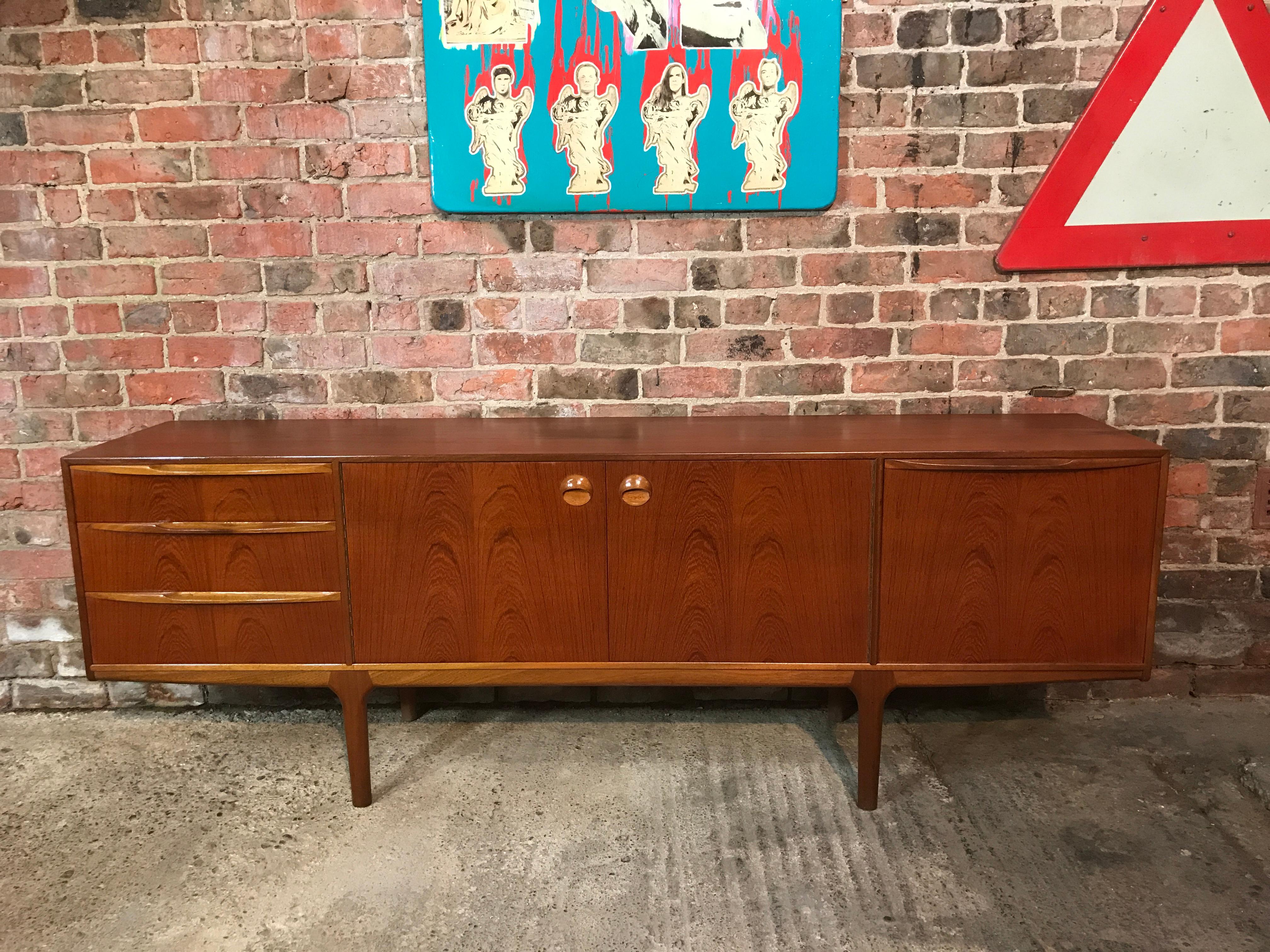 Vintage 1960s McIntosh sideboard by Tom Robertson. It has three drawers, cupboard space with lovely round handles, and a drinks section with a useful pull-out shelf. Credenza is in very good original condition.
