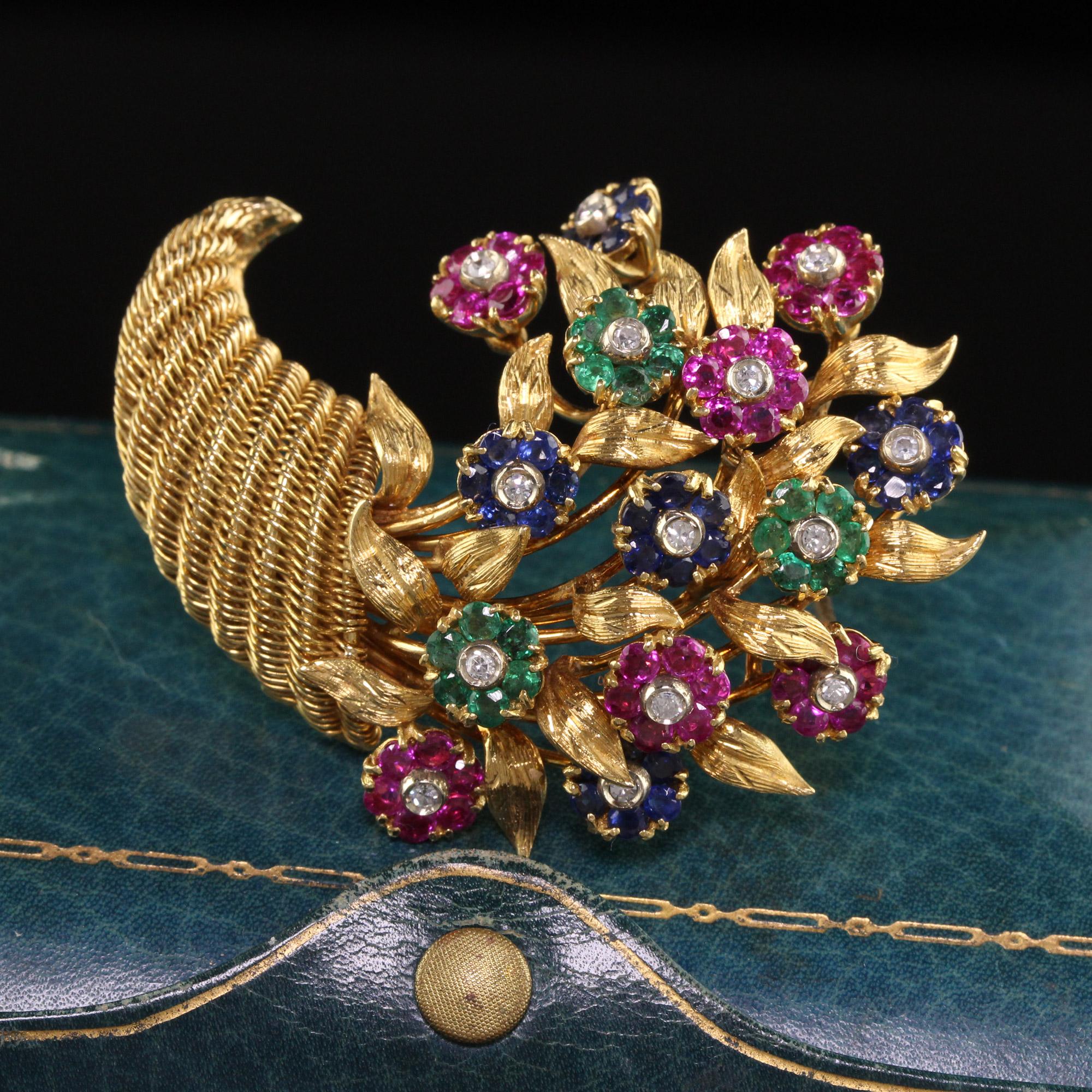 Beautiful Vintage Retro Tiffany and Co 18K Yellow Gold Cornucopia Sapphire Flower Pin. This gorgeous pin is crafted in 18k yellow gold. The pin has natural sapphires, rubies, emeralds, and diamonds set in flower petals that articulate when touched