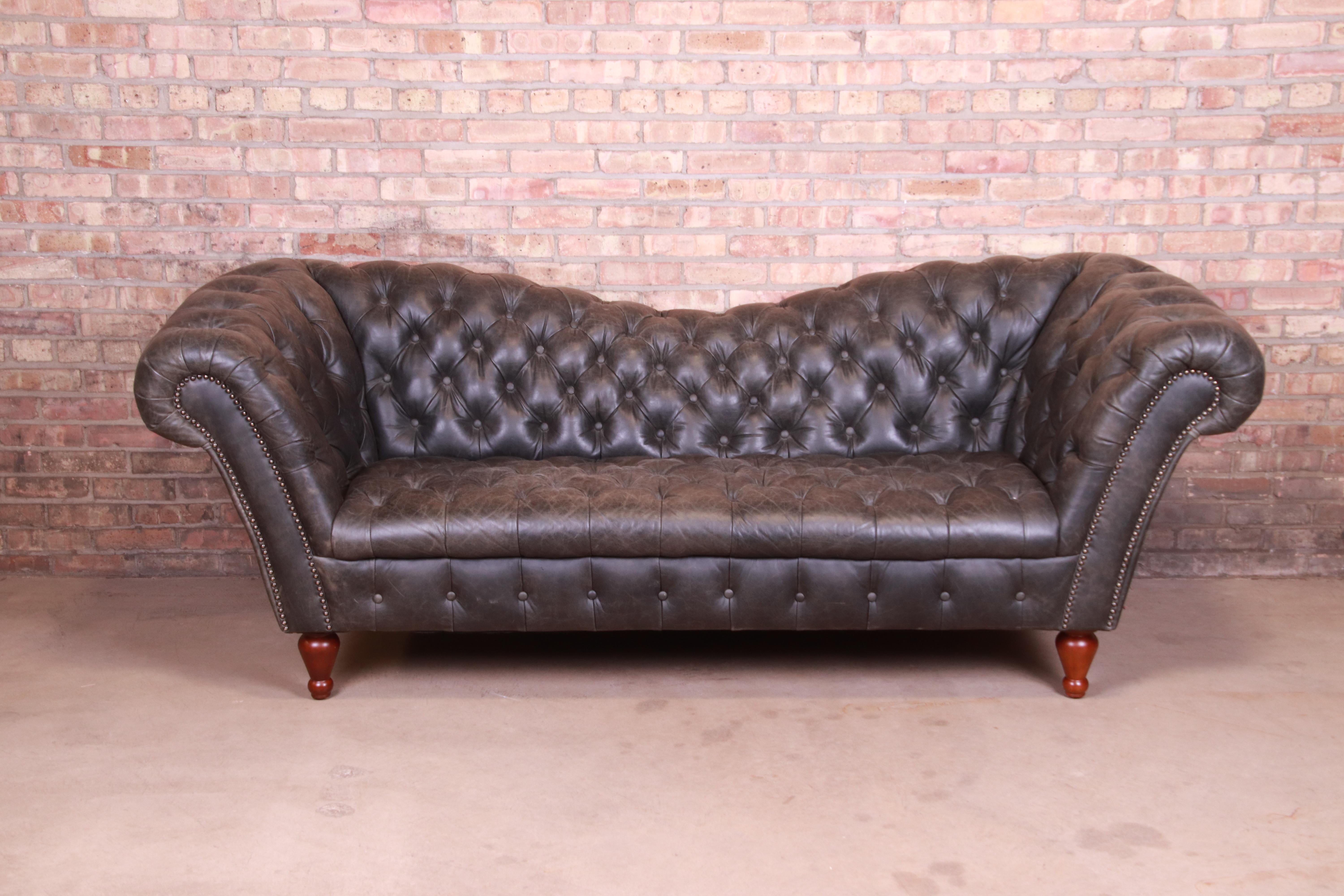 A stunning vintage reverse camelback Chesterfield sofa

Retailed by Neiman Marcus, Chicago

20th century

Tufted charcoal gray leather, with turned mahogany feet.

Measures: 92