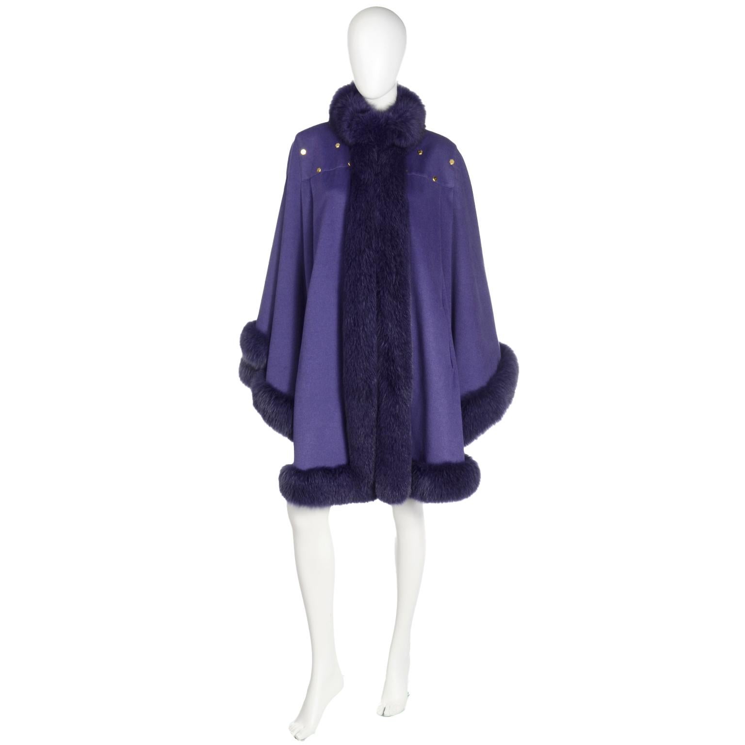 This outstanding 1980's vintage cape from Revillon is in a gorgeous shade of purple and is beautifully trimmed with purple dyed fox fur.  The cape measures 19
