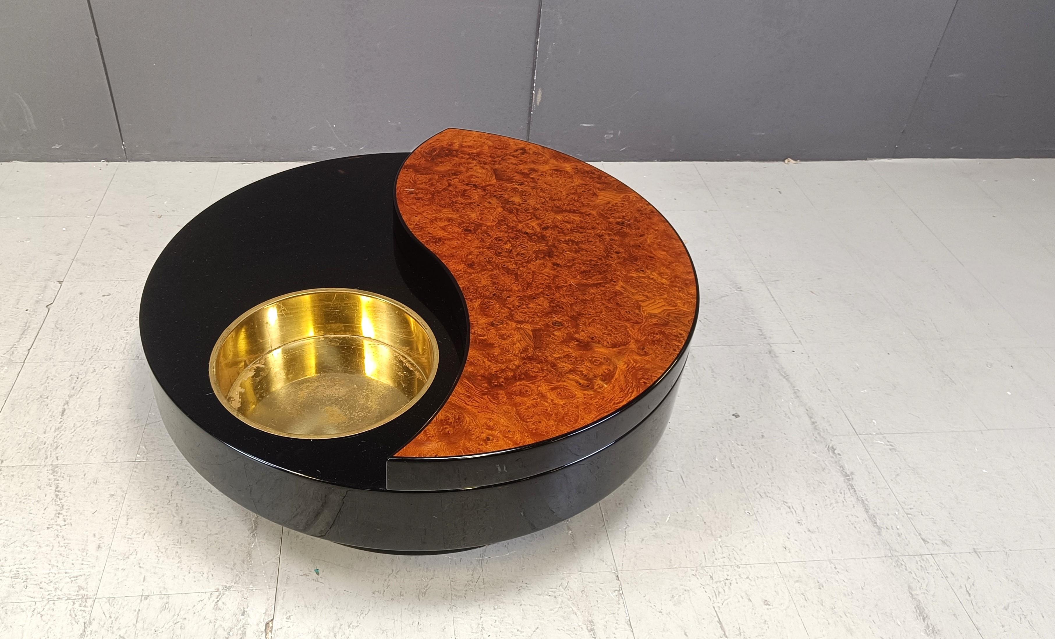 Very rare and amazing coffee table by Willy Rizzo.

This rotating coffee table is a true eye catcher for your living room made out of laminated burl and lacquer with an integrated patinated brass bottle holder.

The ying yang design is what gets