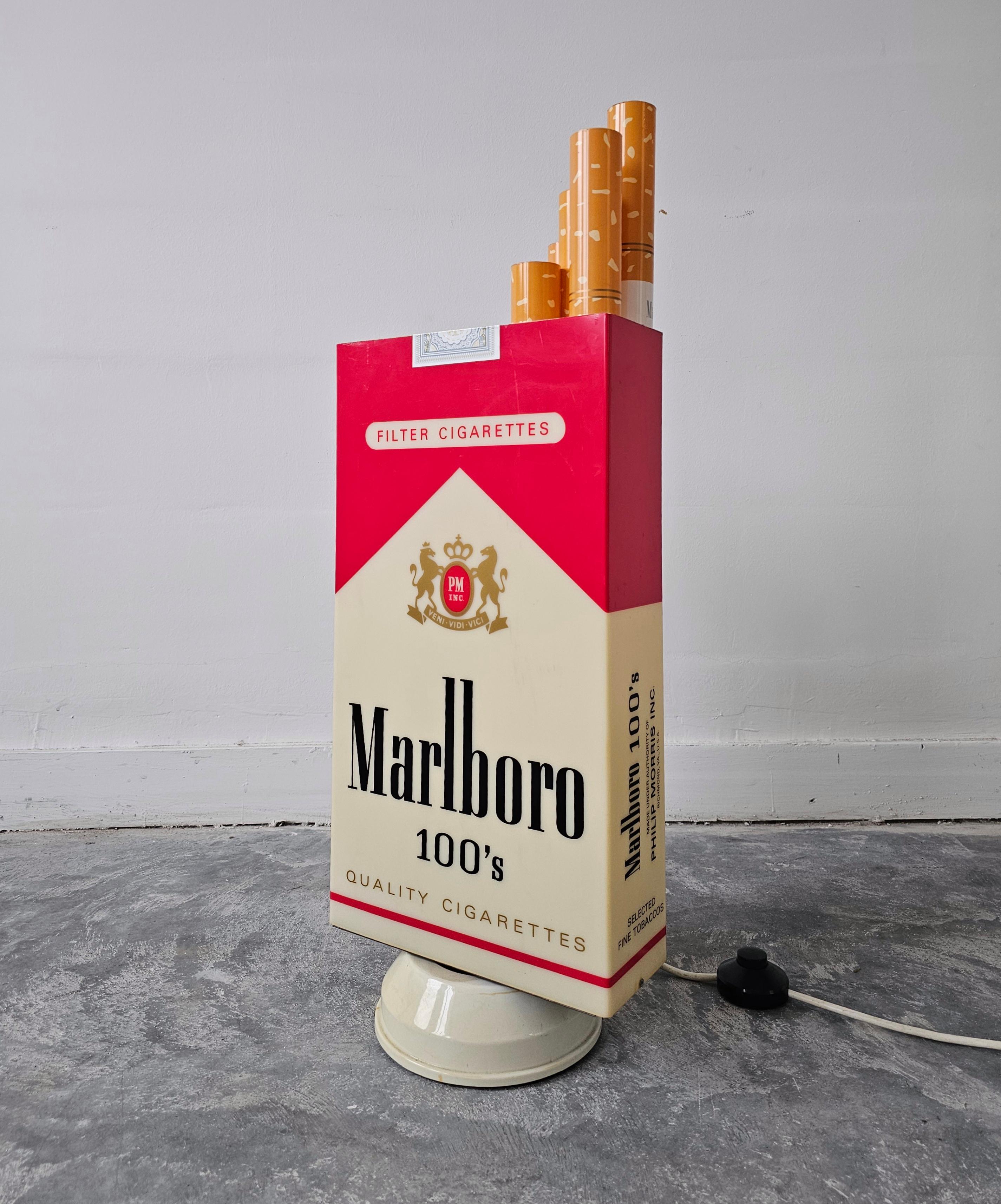 In this listing you will find an extraordinary and very rare light up box depicting Marlboro Cigarette Pack. It was made as an ad, and it features an internal light that lights up when plugged in. In addition to light, the box is set on a metal