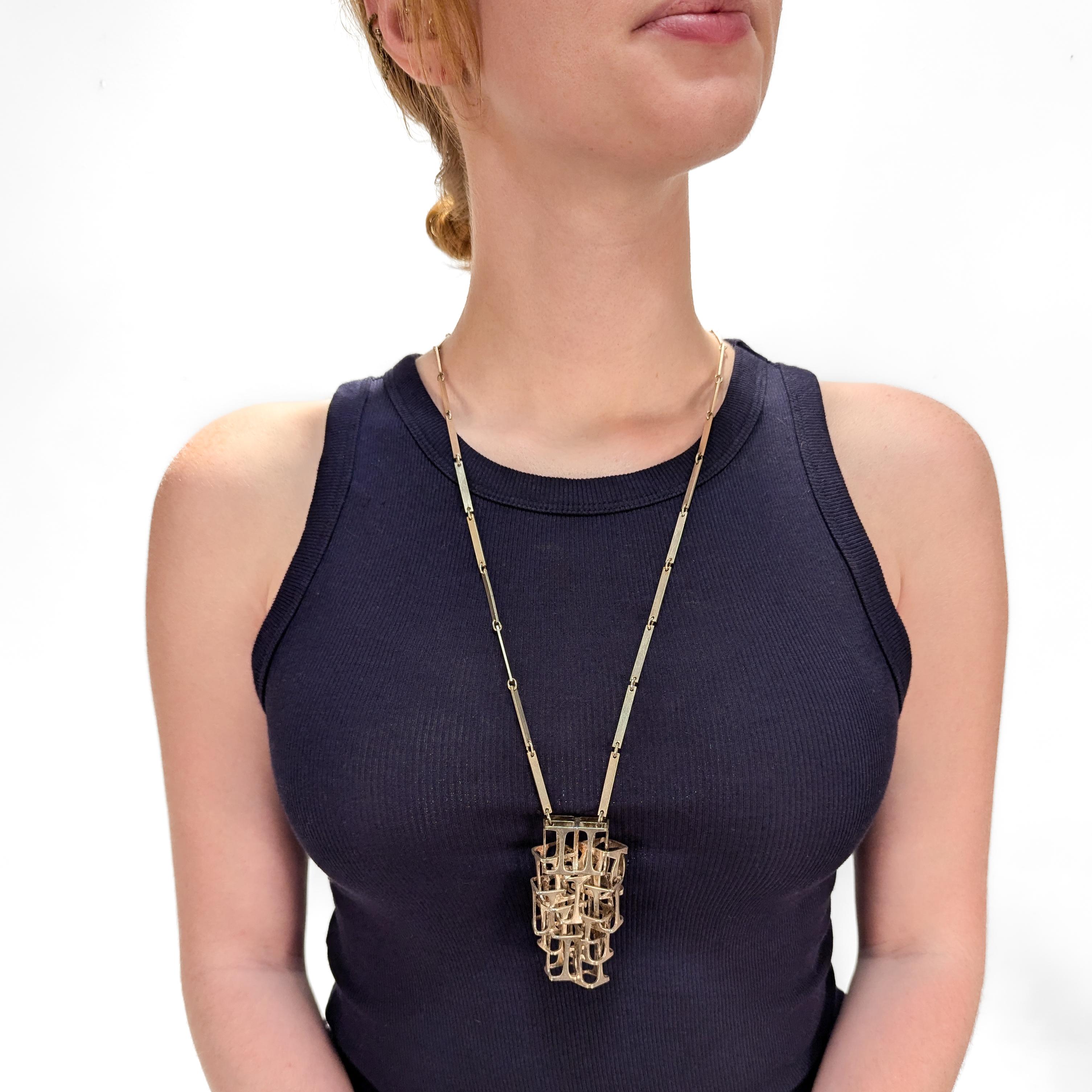 Una raffinata collana con ciondolo firmata Danish Modern. 

In argento sterling.

Creato da Rey Urban per Age Fausing.

Composto da numerosi prismi rettangolari fusi insieme come ciondolo e sospesi da una collana a maglie.

Con chiusura a gancio e