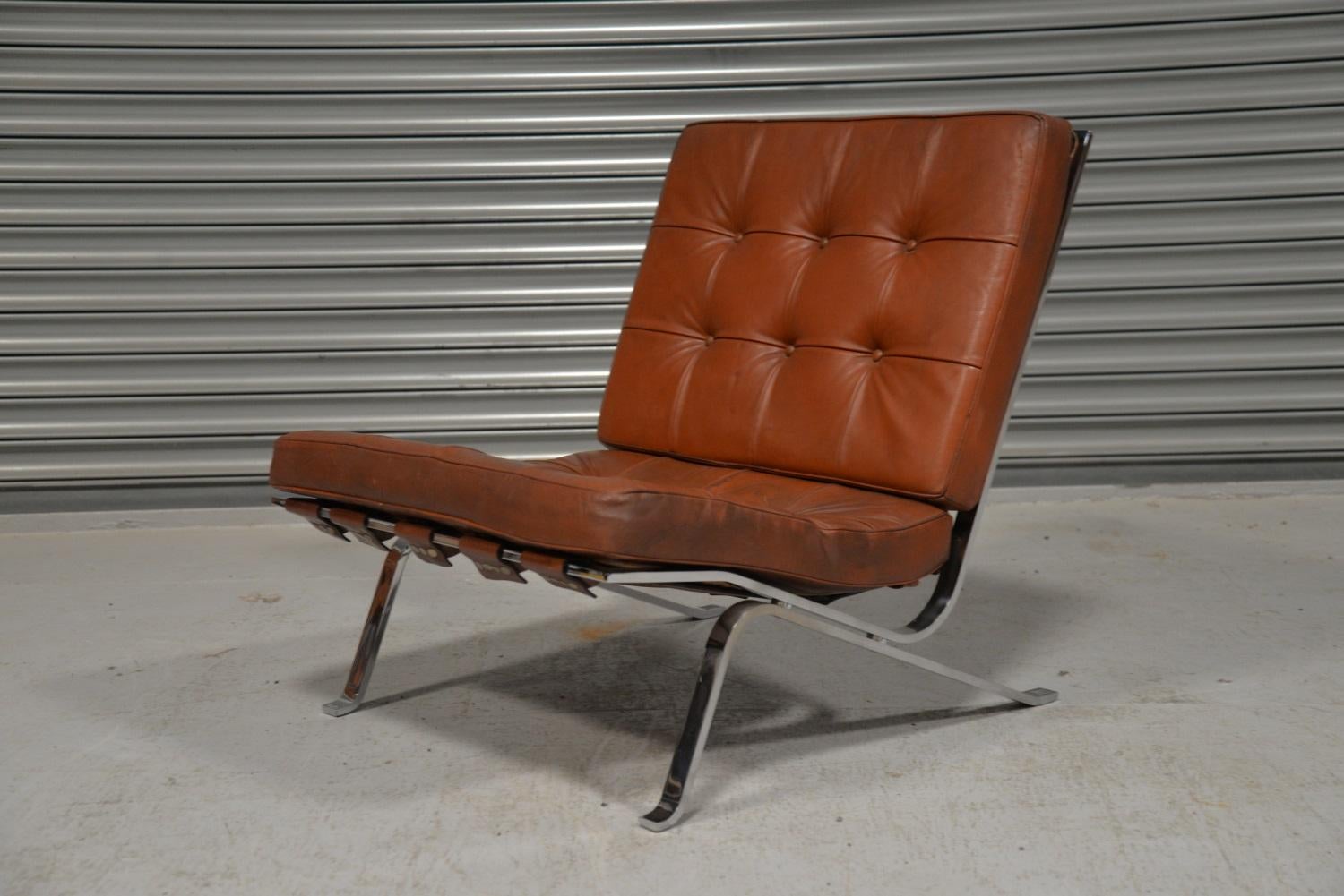 We are delighted to bring to you a rare vintage RH-301 flat bar lounge chair in original tan leather designed by Robert Haussmann for de Sede. Hand built in the 1950s this rare lounge chair has a chrome plated steel frame with leather strap