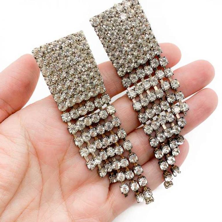 A wonderful pair of Vintage Rhinestone Chandelier Earrings hailing from the 1980s. Featuring rows and rows of shimmering rhinestones. Clip fasteners. Measuring approx. 9cm and in very good vintage condition. These totally iconic rhinestone