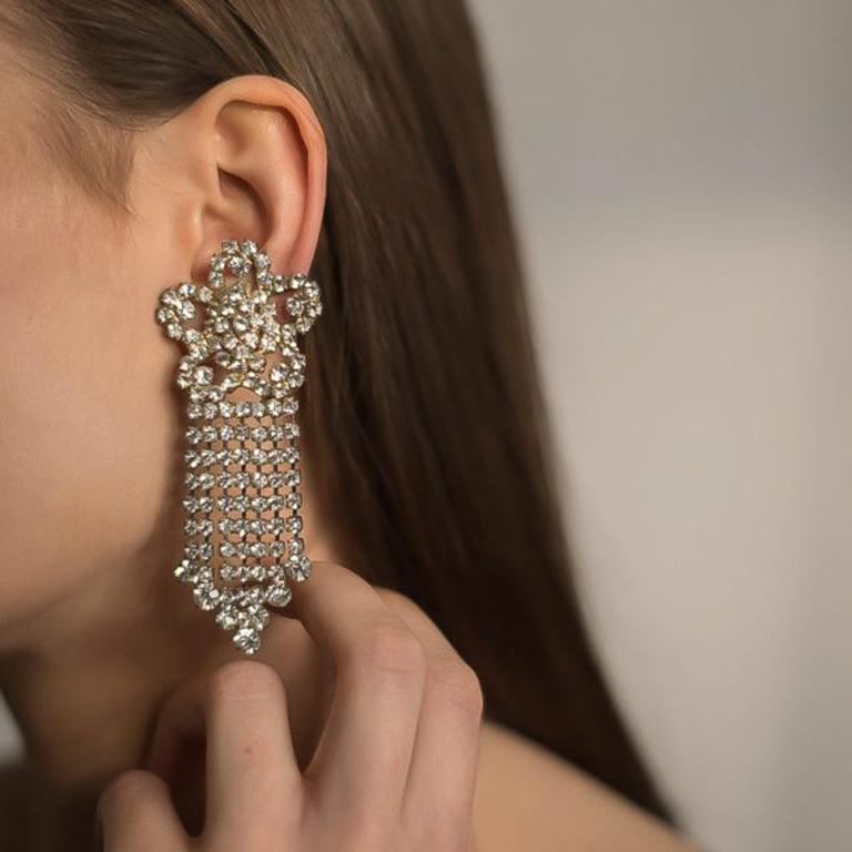 Eye catching to say the least. These clip on Vintage Rhinestone Floral Chandelier Earrings hail from the prolifically glamorous 1980s. Featuring rows and rows of shimmering rhinestones. Clip fasteners. Measuring approx. 8cm long and in very good