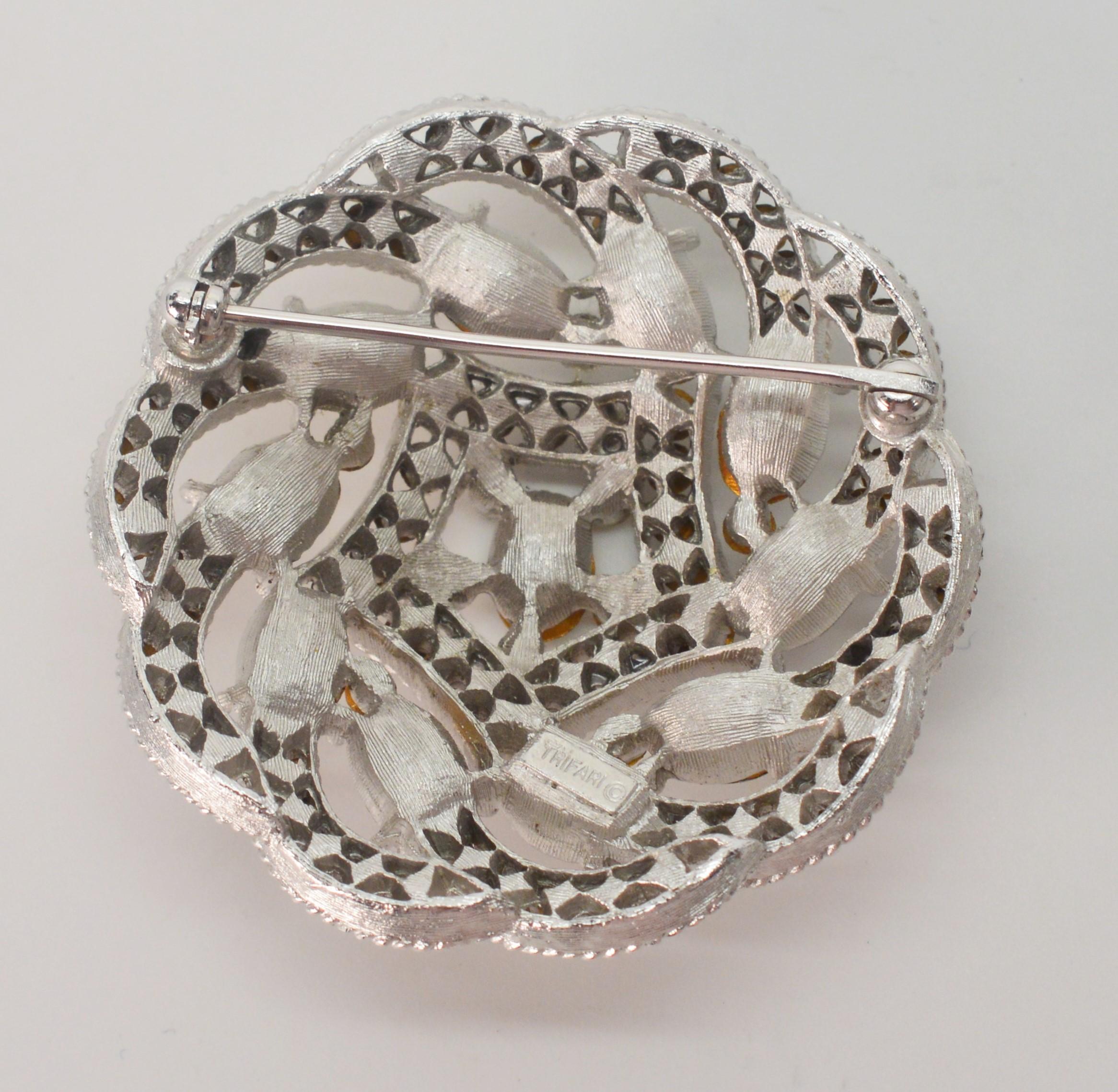 A vintage classic,  this beautifully designed costume brooch with its clear oval rhinestones lights up any outfit with brilliance.
Measuring 1-7/8 inch round and in excellent condition with only light wear. Makers silver-toned base metal and stamped