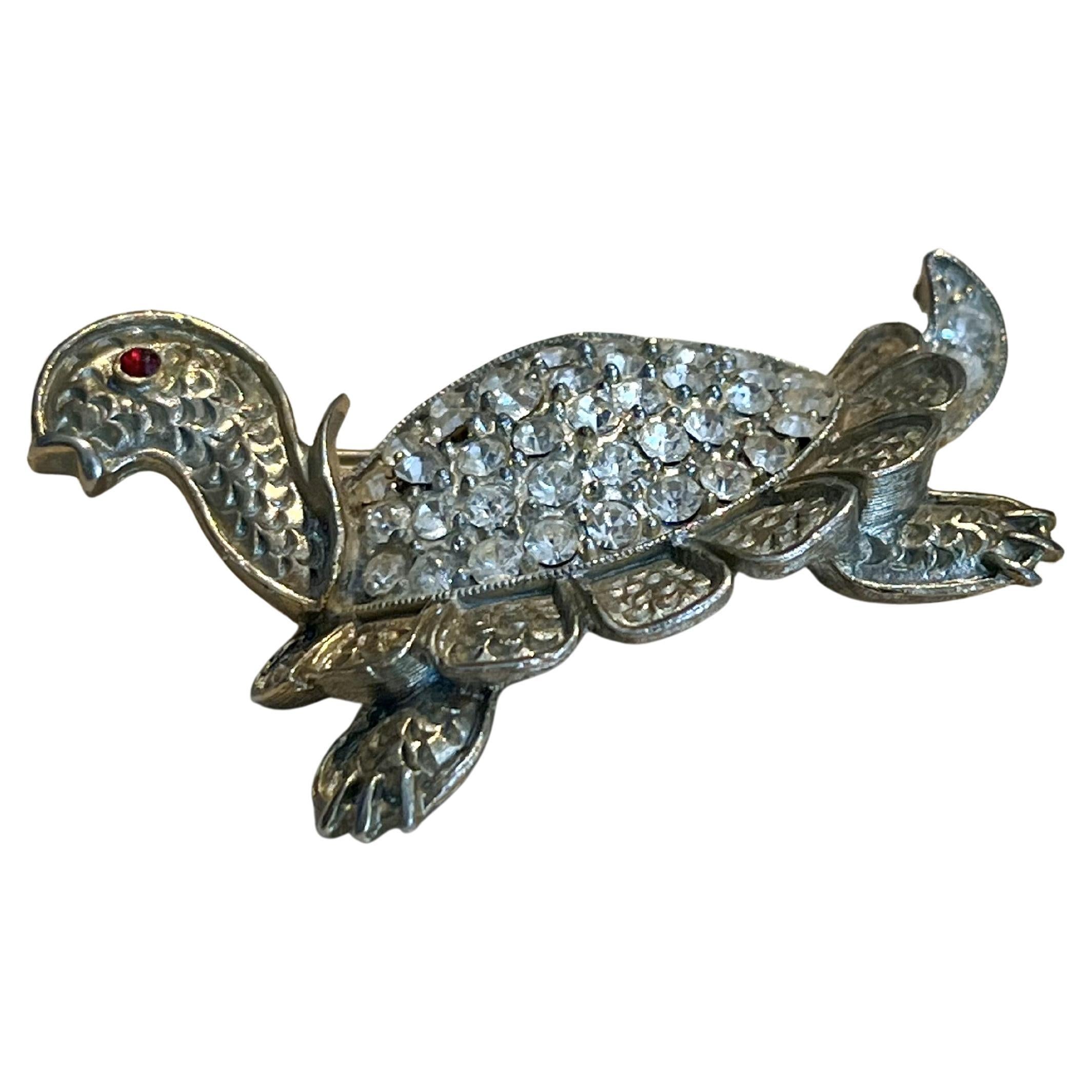 This Vintage Rhinestone Turtle Brooch is a sparkling and charming piece of jewelry that combines the playful nature of a turtle with the elegance of rhinestones. Rhinestone brooches from vintage collections often feature intricate designs and