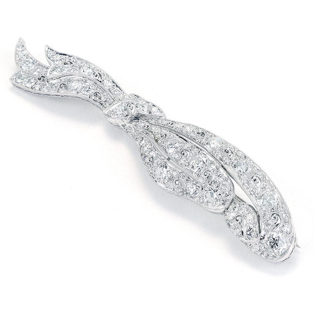This pin is made of platinum and 14K white gold and weighs 7.20 DWT (approx. 11.2 grams). It contains 93 European cut diamonds weighing 6.00 CTTW. Dimensions: 3.0