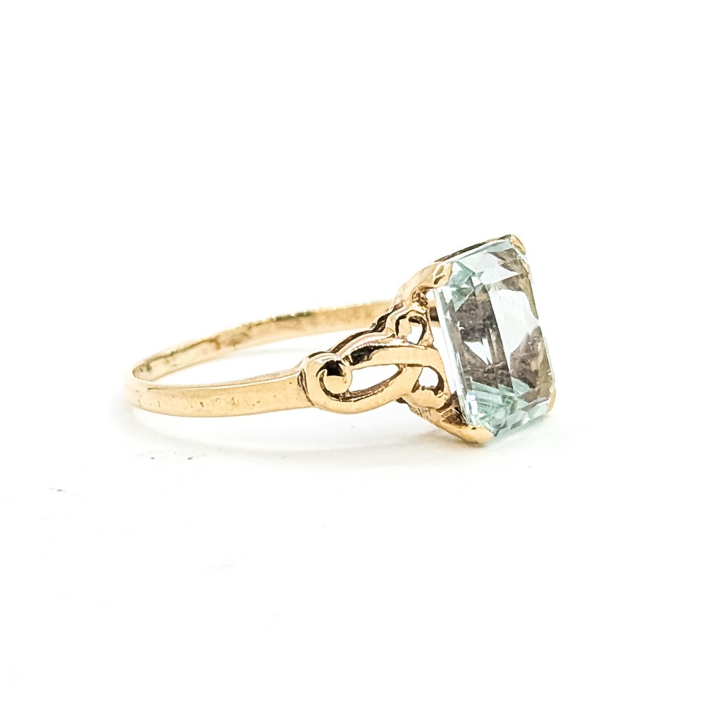Vintage Ribbon-Style Aquamarin Ring in 10k Gelbgold

Dieser Vintage-Ring ist aus 10 Karat Gelbgold gefertigt und trägt einen himmelblauen Aquamarin mit einem Gewicht von etwa 2 Karat. Der Aquamarin im Smaragdschliff ist in einer offenen,