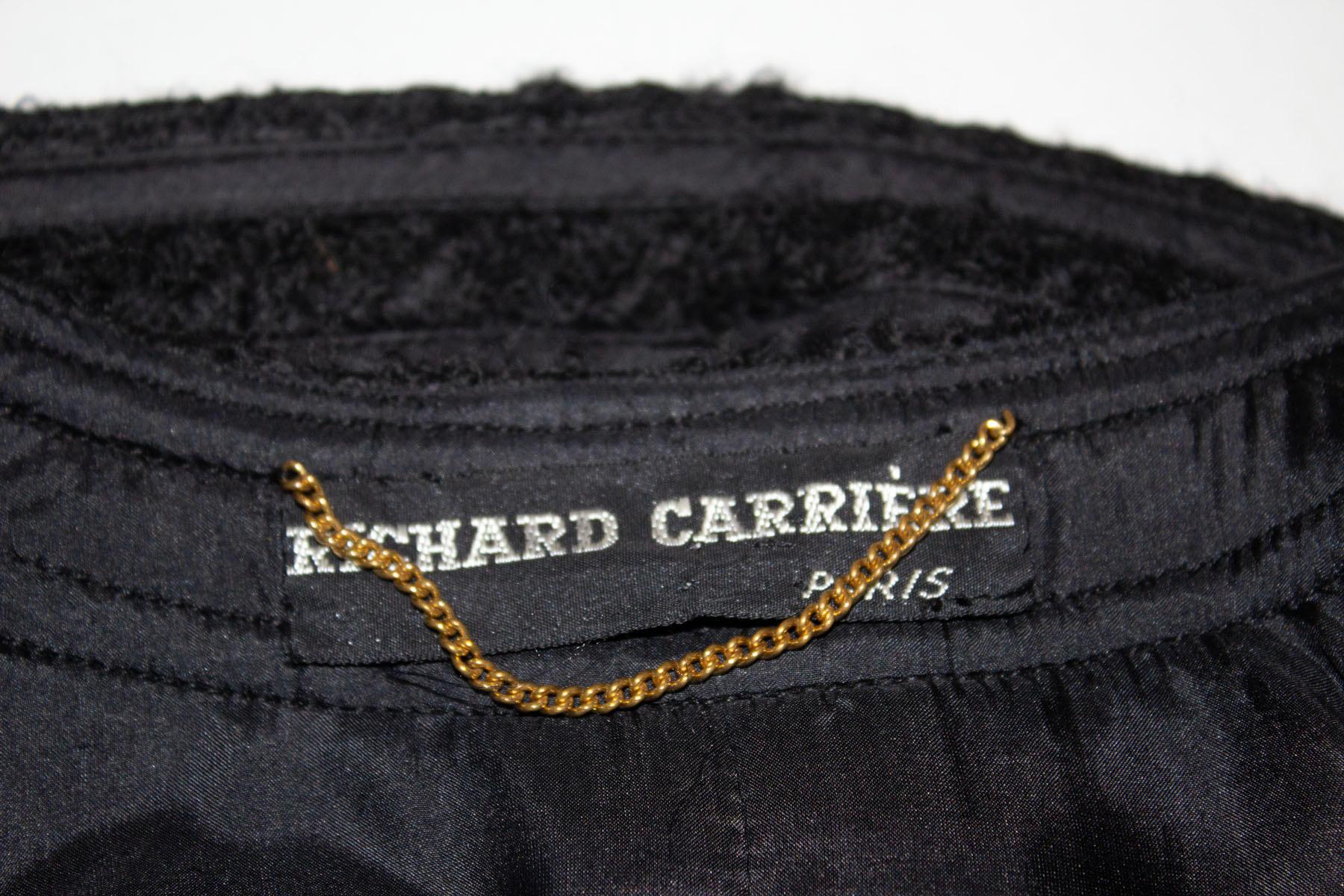 A vintage Richard Carriere Paris, hand finished Chanel style couture jacket. The jacket is in a black wool and has an eight button front opening, four pockets on the front, and a chain in the hem. Measurements: Bust up to 41'', length 22''