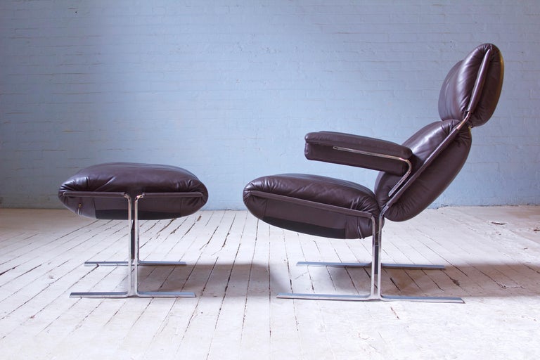 A substantial and supportive lounge chair & footstool in top-grain leather dark brown designed by Richard Hersberger; fabricated by Saporiti for Pace Collection, 1970s. Solid chromium-plate tempered steel bolted construction supports supple Italian