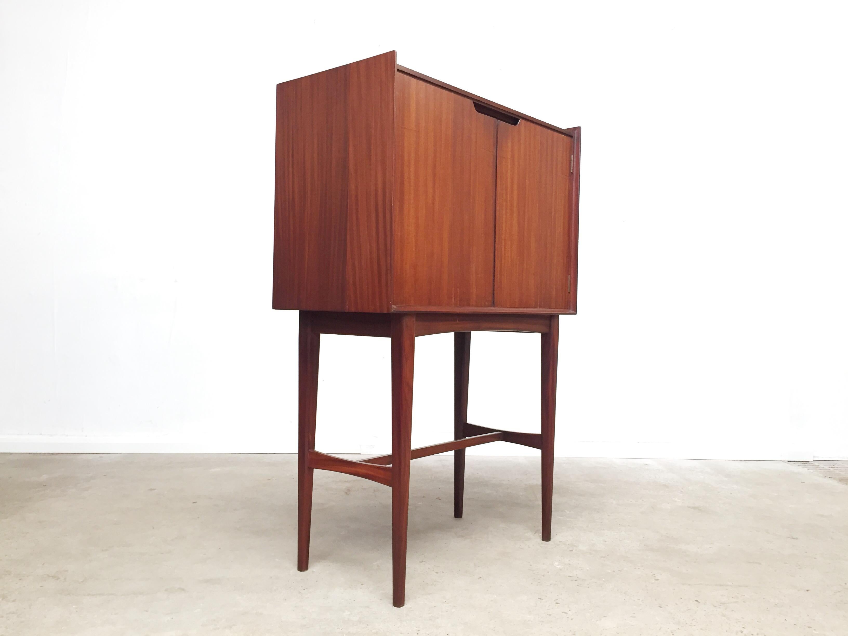 British designer Richard Hornby. He is largely famous for his one range for the Banbury based company Fyne Ladye, all of which (a dining set, a writing bureau, sideboard etc) all were expertly carved from solid Aformosia (a now endangered West