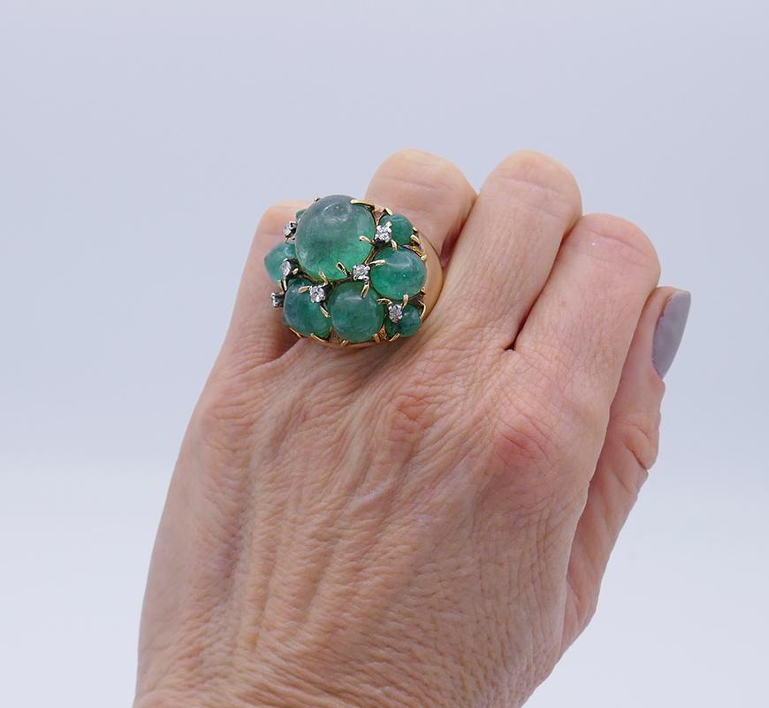        A whimsical vintage ring made of 14 karat yellow gold featuring cabochon emerald.
The cabochon emeralds are staged as a free form cluster, with a bigger stone in the middle. Being a part of the design, the prong setting creates a berry-like