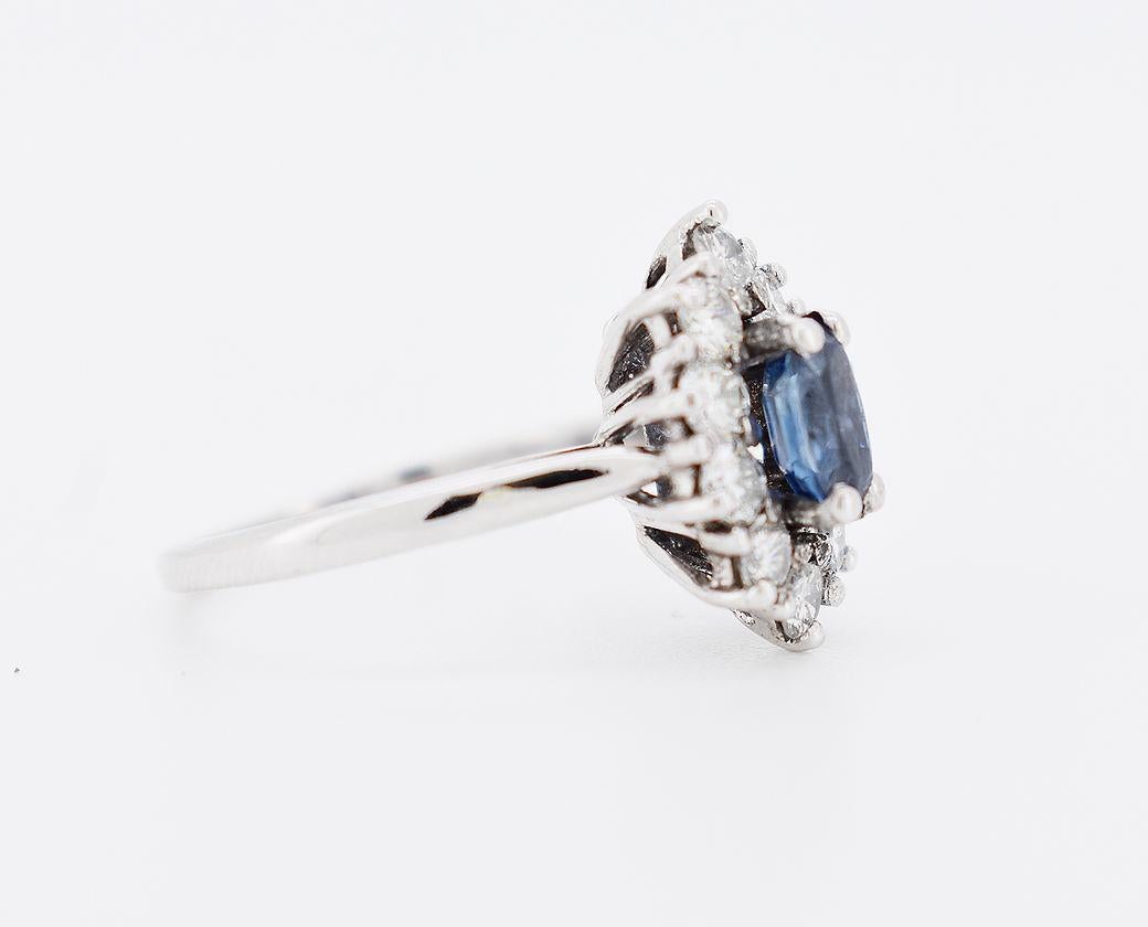 Bague Vintage (circa 1970) en or blanc 18 carats (750 millièmes). Elle est ornée de diamants taille brillant entourant un saphir naturel ovale d'environ 0,50 carat. Le saphir mesure 6 x 4 x 3 mm.

Caractéristiques détaillées

Poids : 4g
Taille : 51